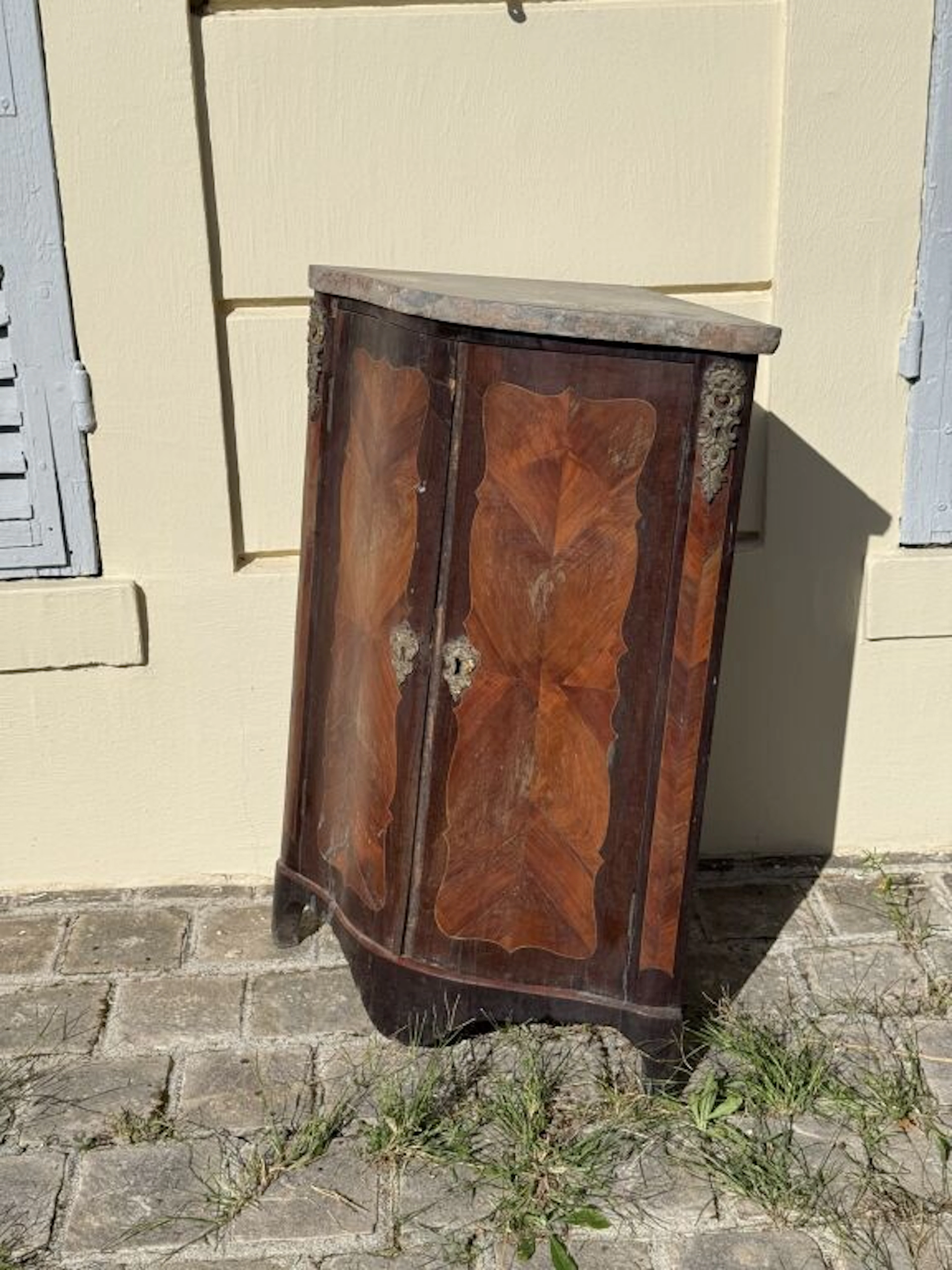 Veneered wooden corner cabinet with butterfly-wing marquetry decoration