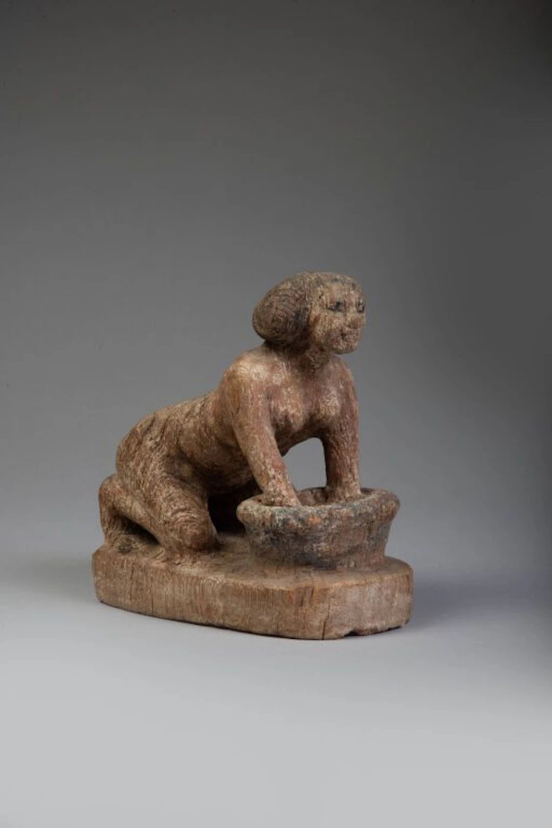 Statuette of a woman at work. A free-standing statuette depicting