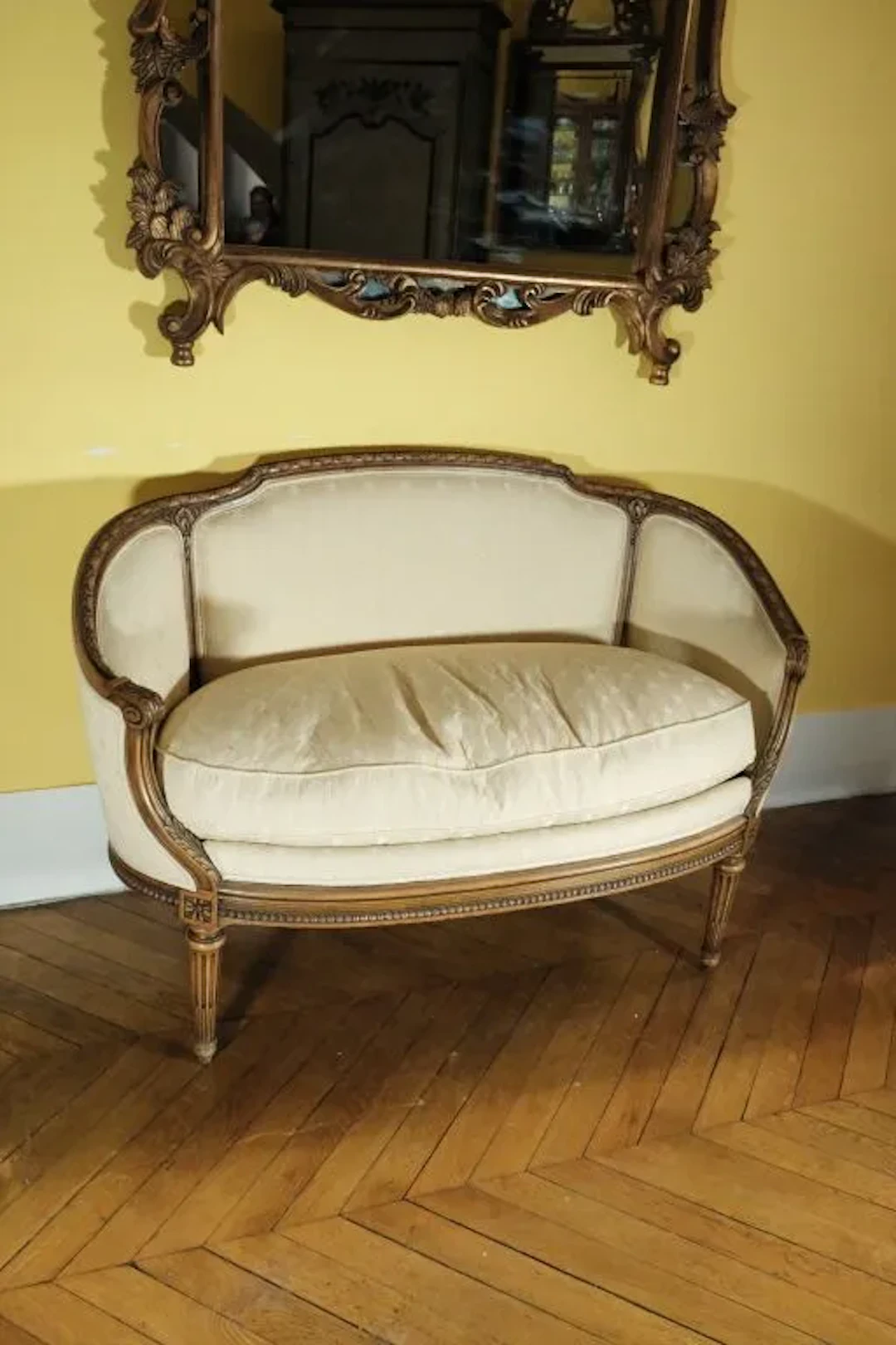 Small sofa with a wraparound backrest made of molded wood, carved