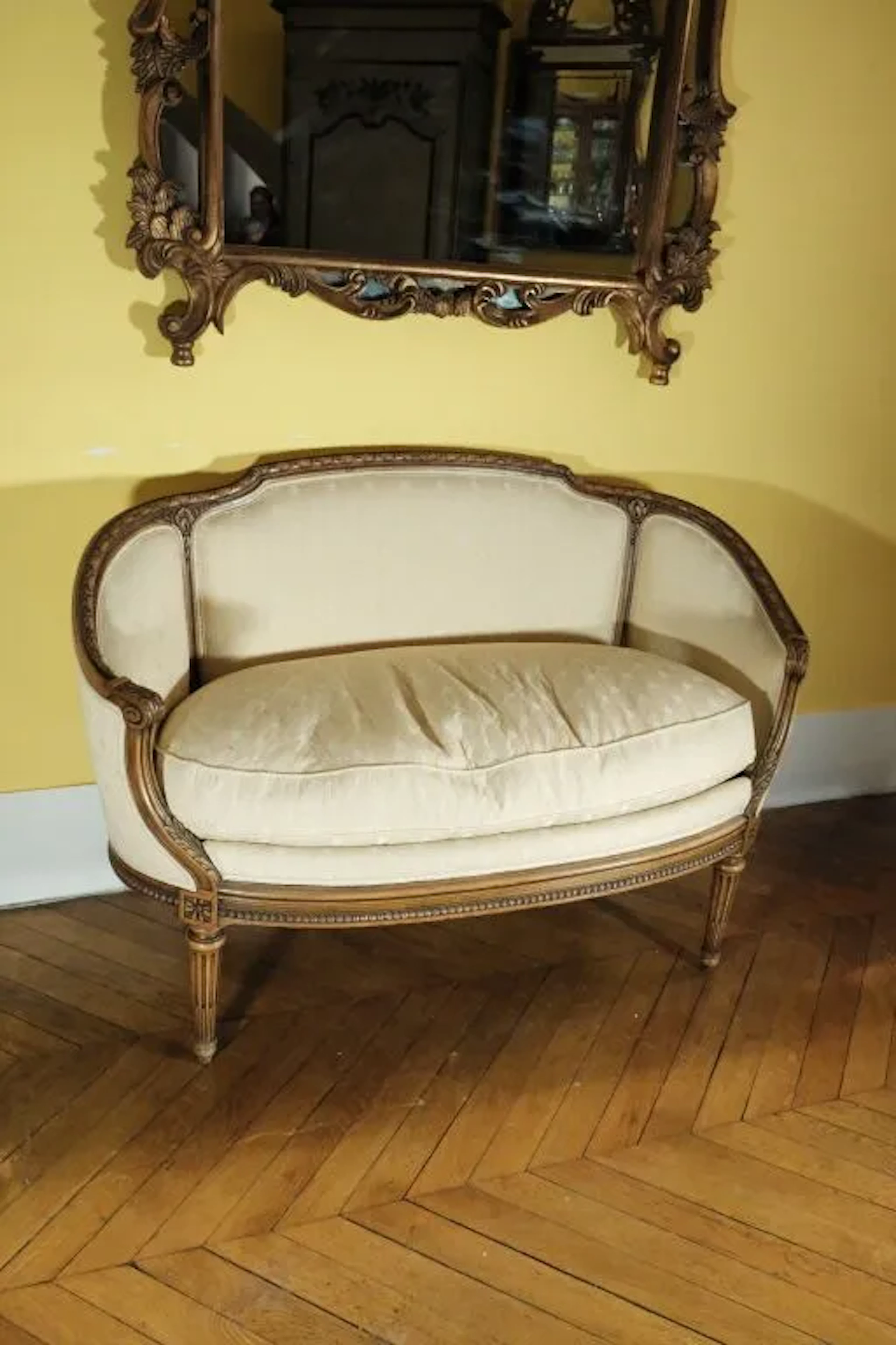 Small sofa with a wraparound backrest made of molded wood, carved
