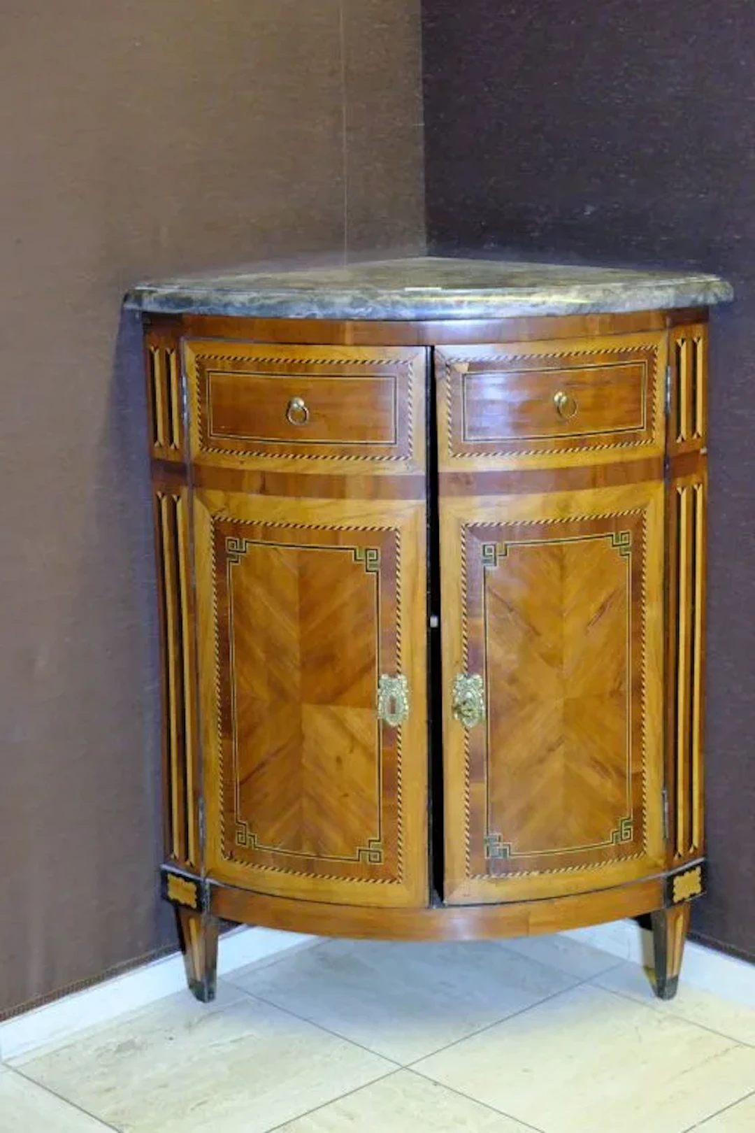 Small corner cabinet made of wood veneer arranged in a curly pattern