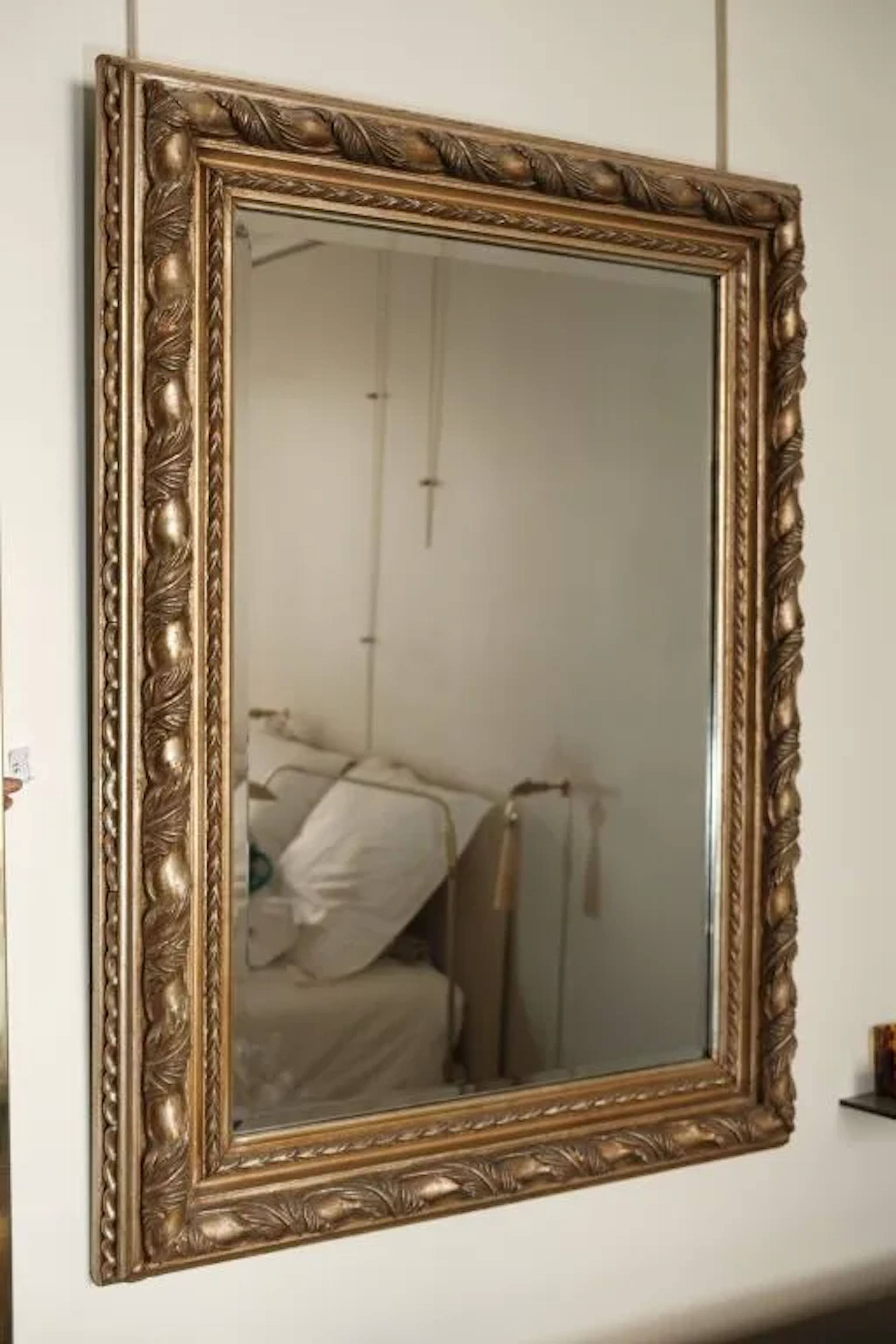 Rectangular beveled mirror set in a stuccoed wooden frame featuring