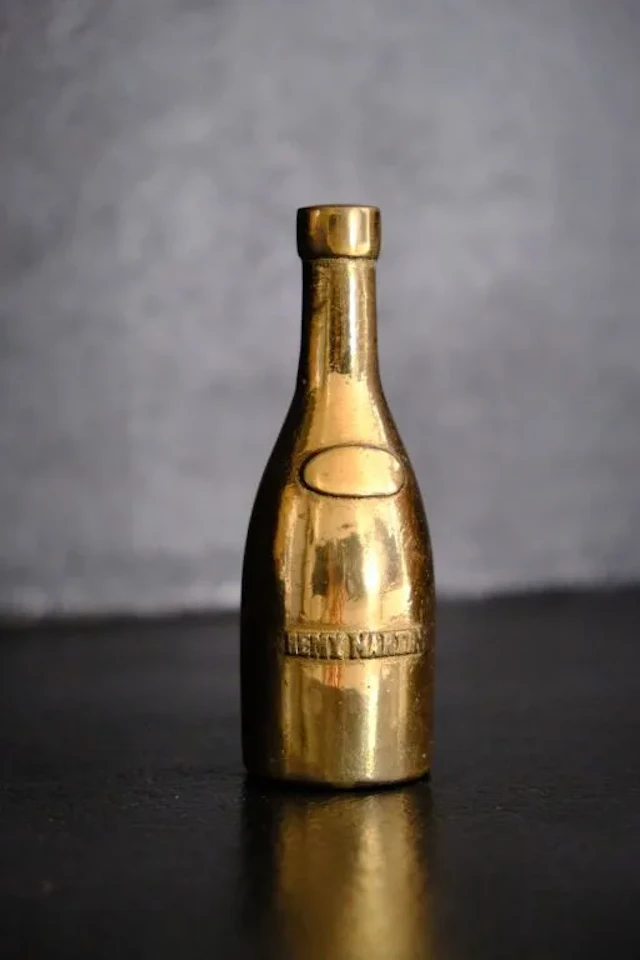Small bronze paperweight shaped like a Rémy MARTIN cognac bottle.
