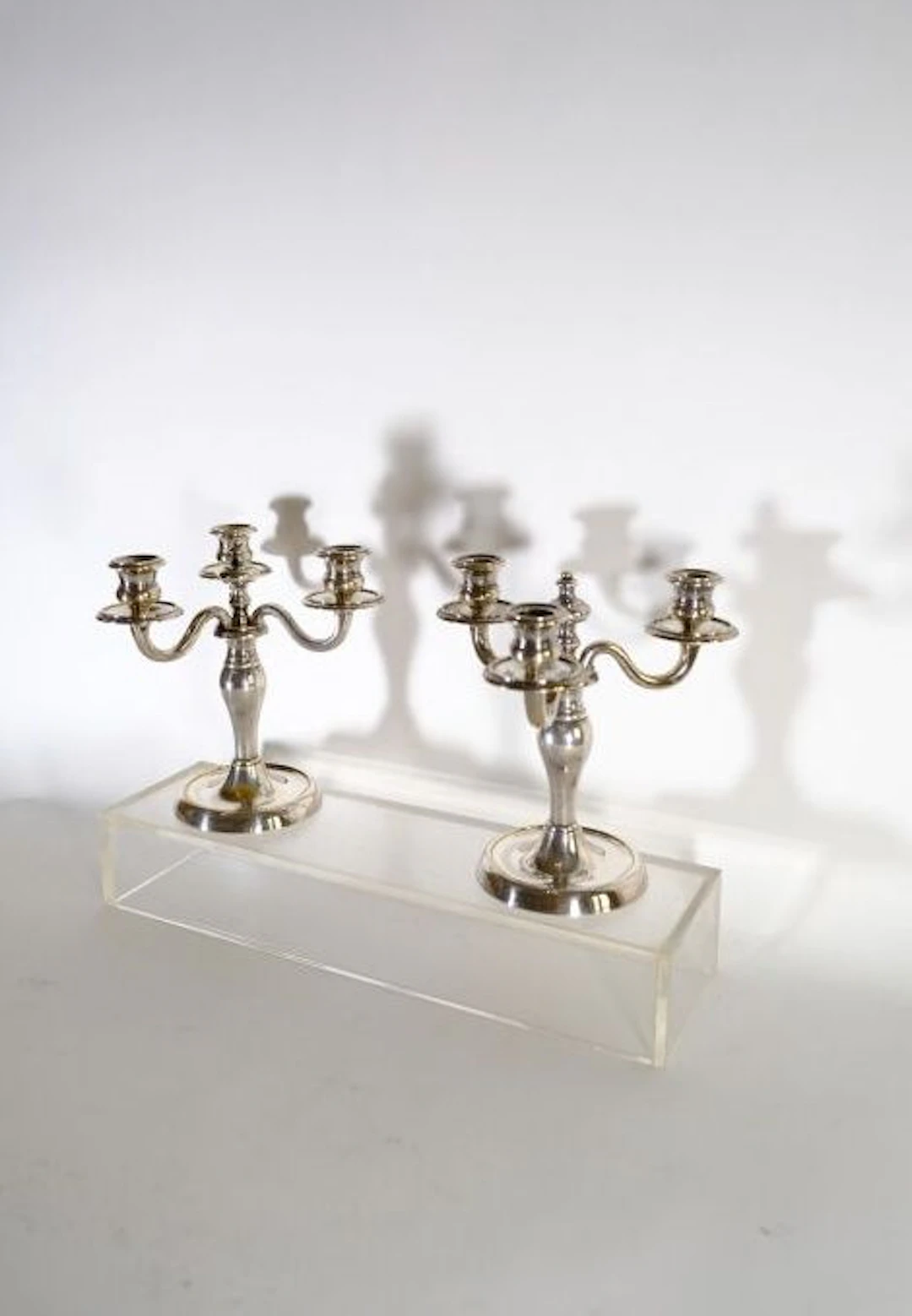 Pair of three-arm candelabras in silver-plated bronze. H.: 22 cm.