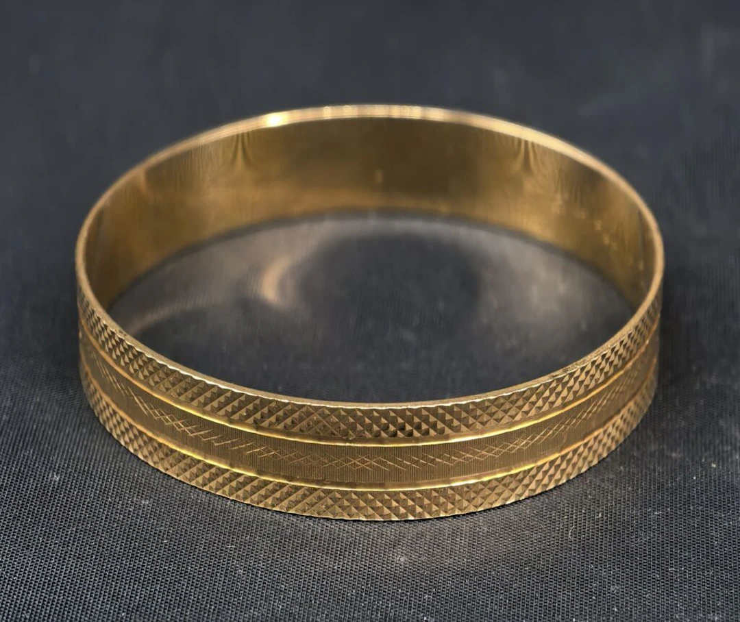 A solid, closed bracelet in chiseled 750‰ yellow gold, engraved with