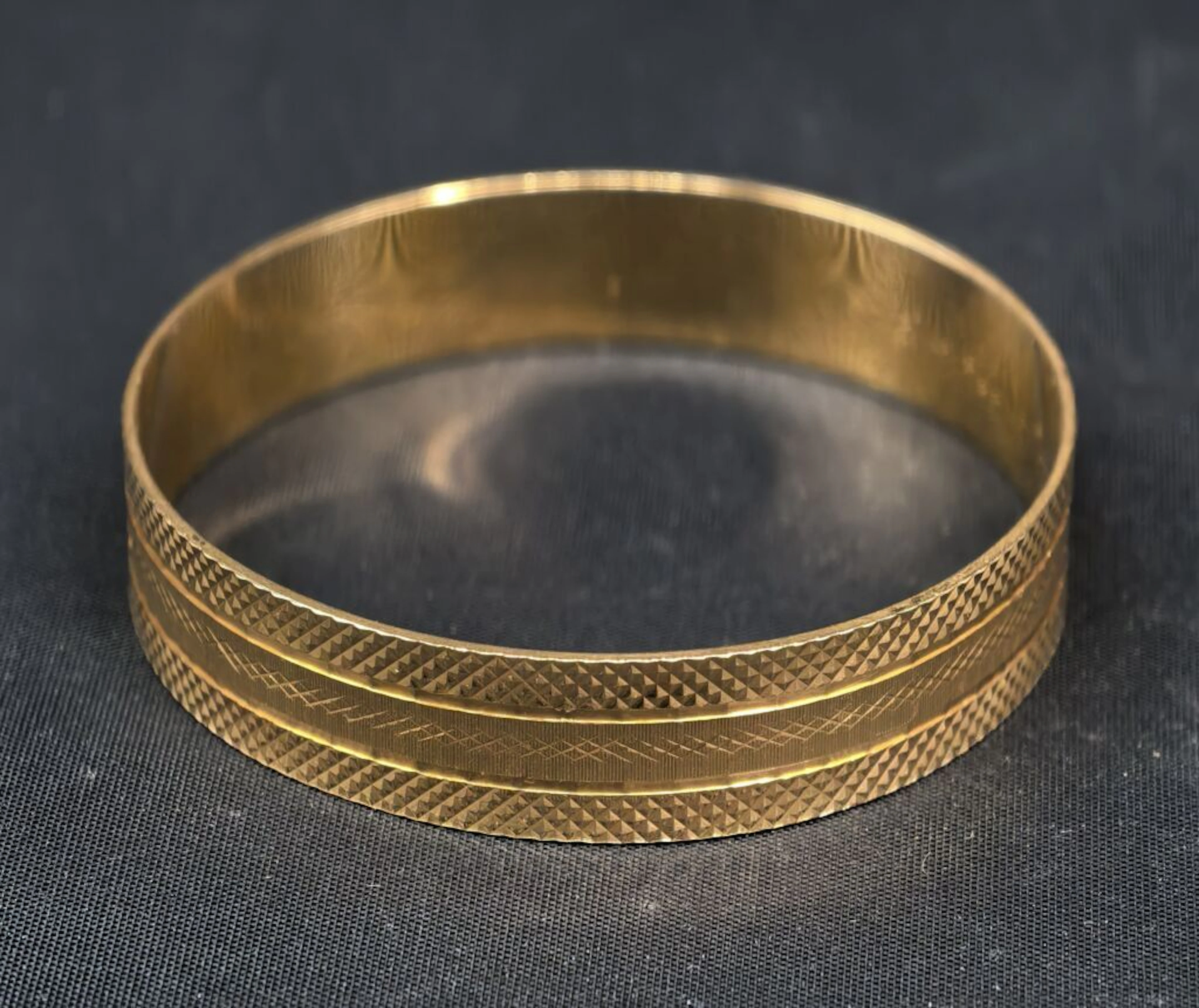 A solid, closed bracelet in chiseled 750‰ yellow gold, engraved with
