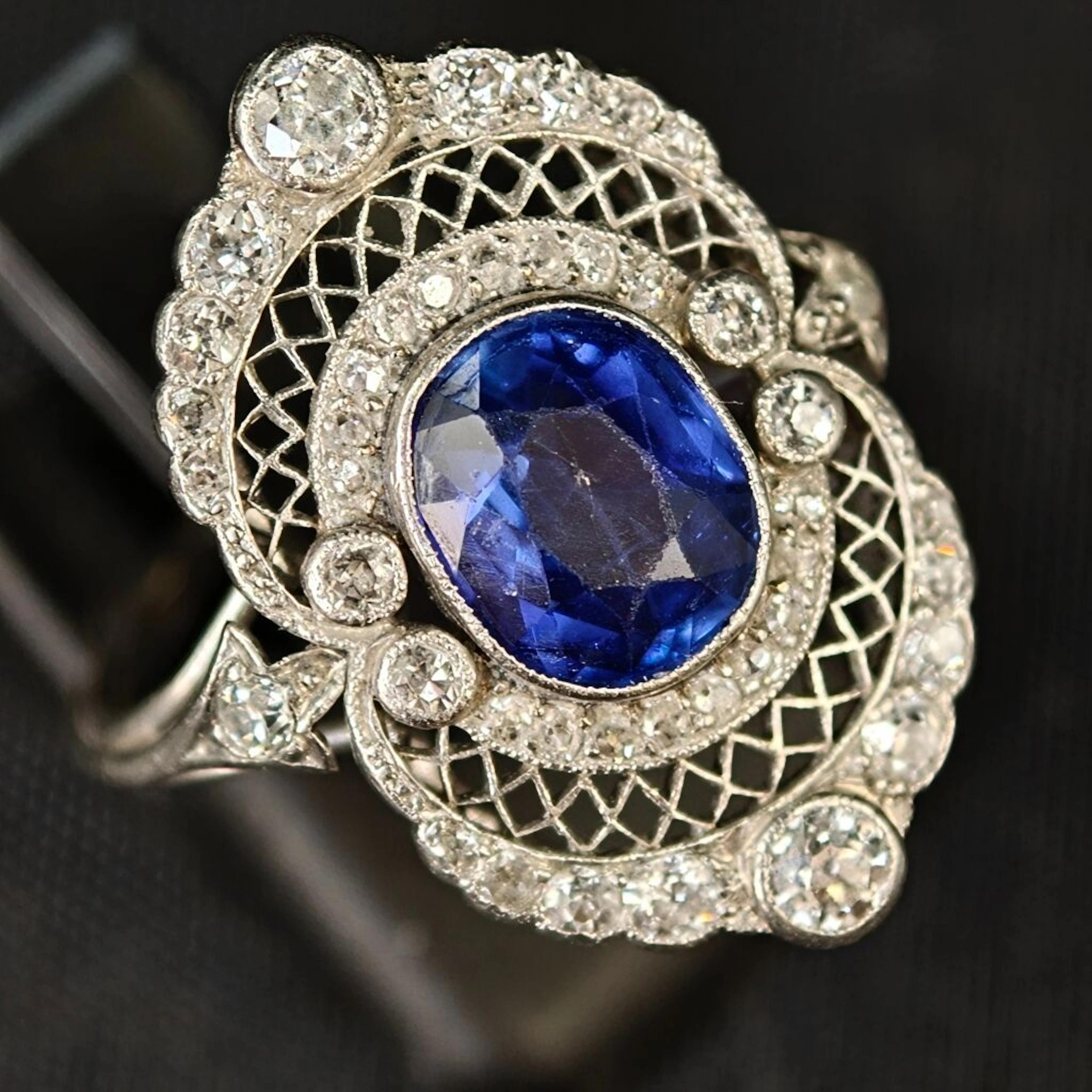 A 950‰ platinum lace-style ring set with an unheated oval sapphire