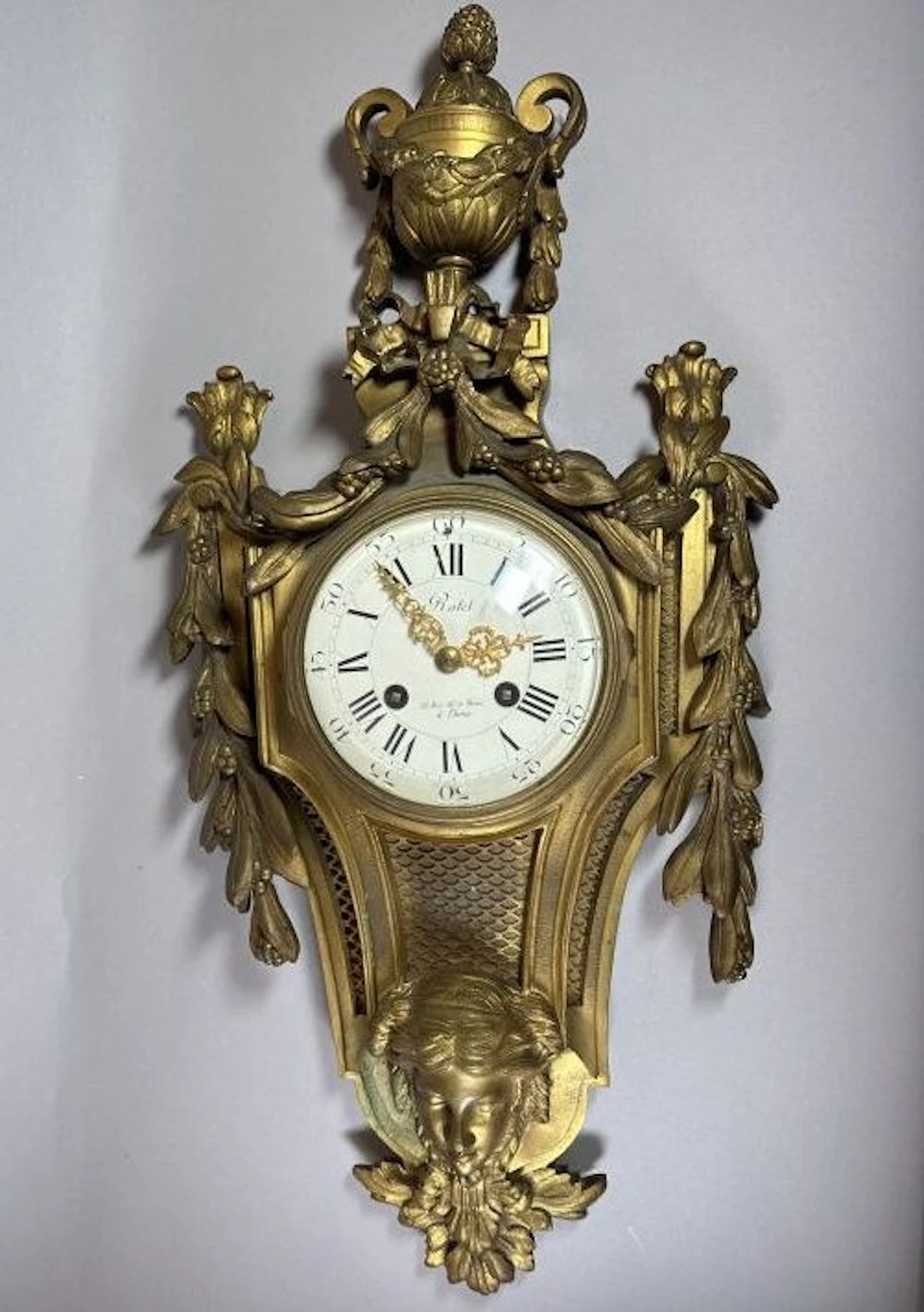 CARTEL. Louis XVI-style bronze wall clock, topped by an antique-style