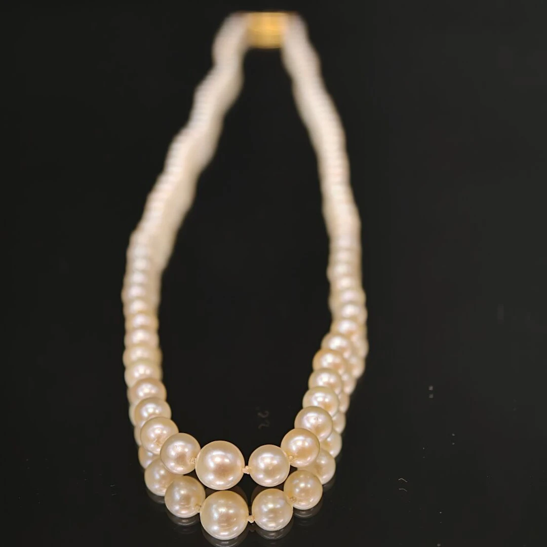 Cascading cultured pearl necklace with an olive clasp and a safety