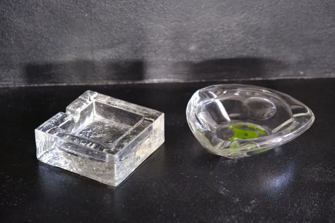 Two ashtrays, one made of frosted crystal, the other made of glass