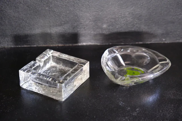 Two ashtrays, one made of frosted crystal, the other made of glass