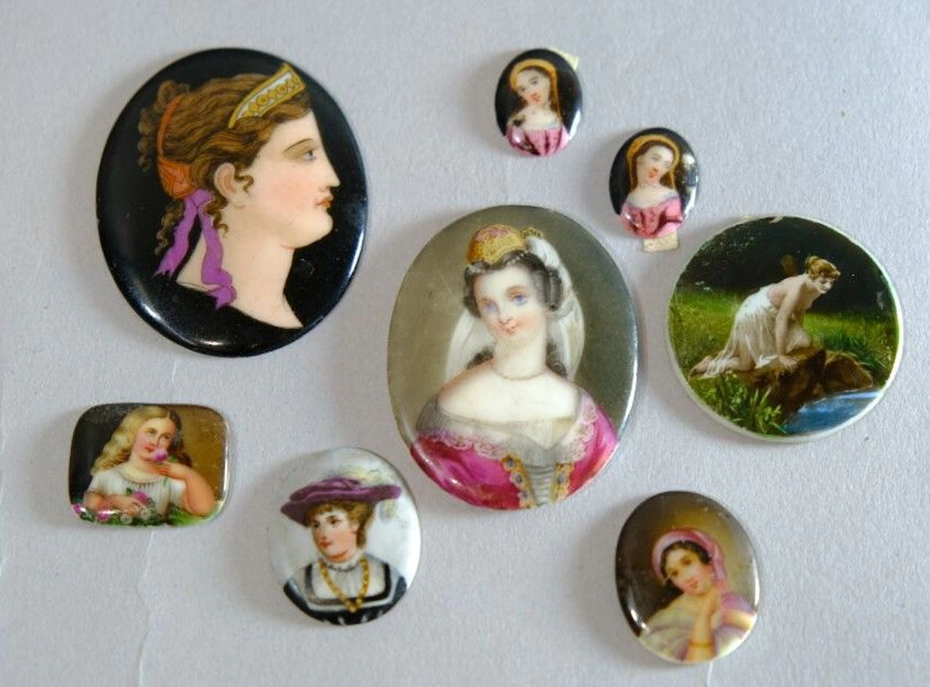 A set of 8 small 19th-century painted porcelain plaques, including: