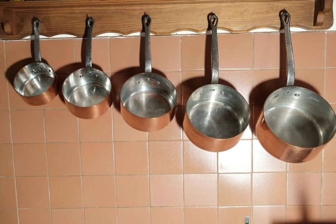 Set of six tin-plated copper pots with wrought-iron handles. Dimensions