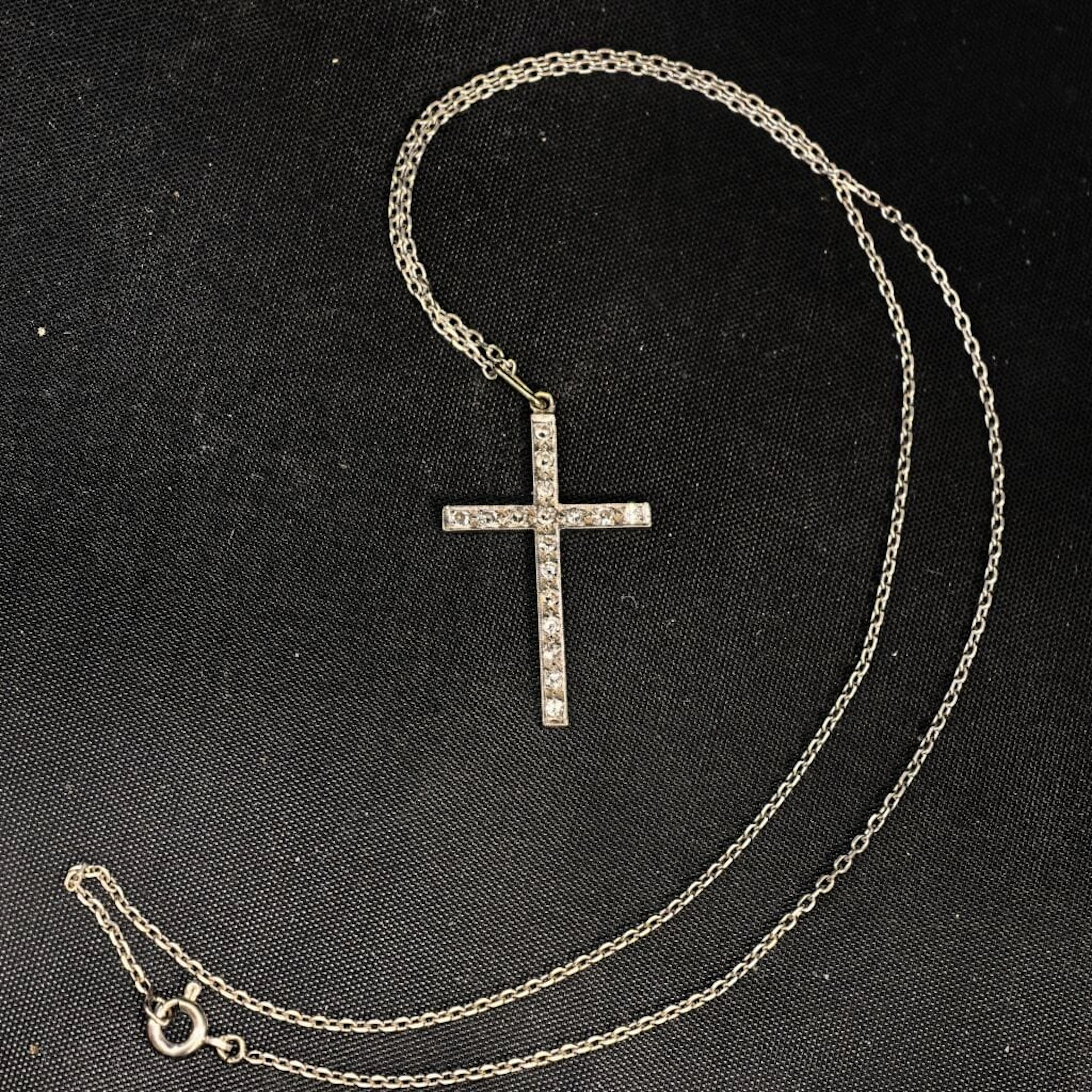 A 750‰ white gold pendant featuring a cross set with eight-eight-cut