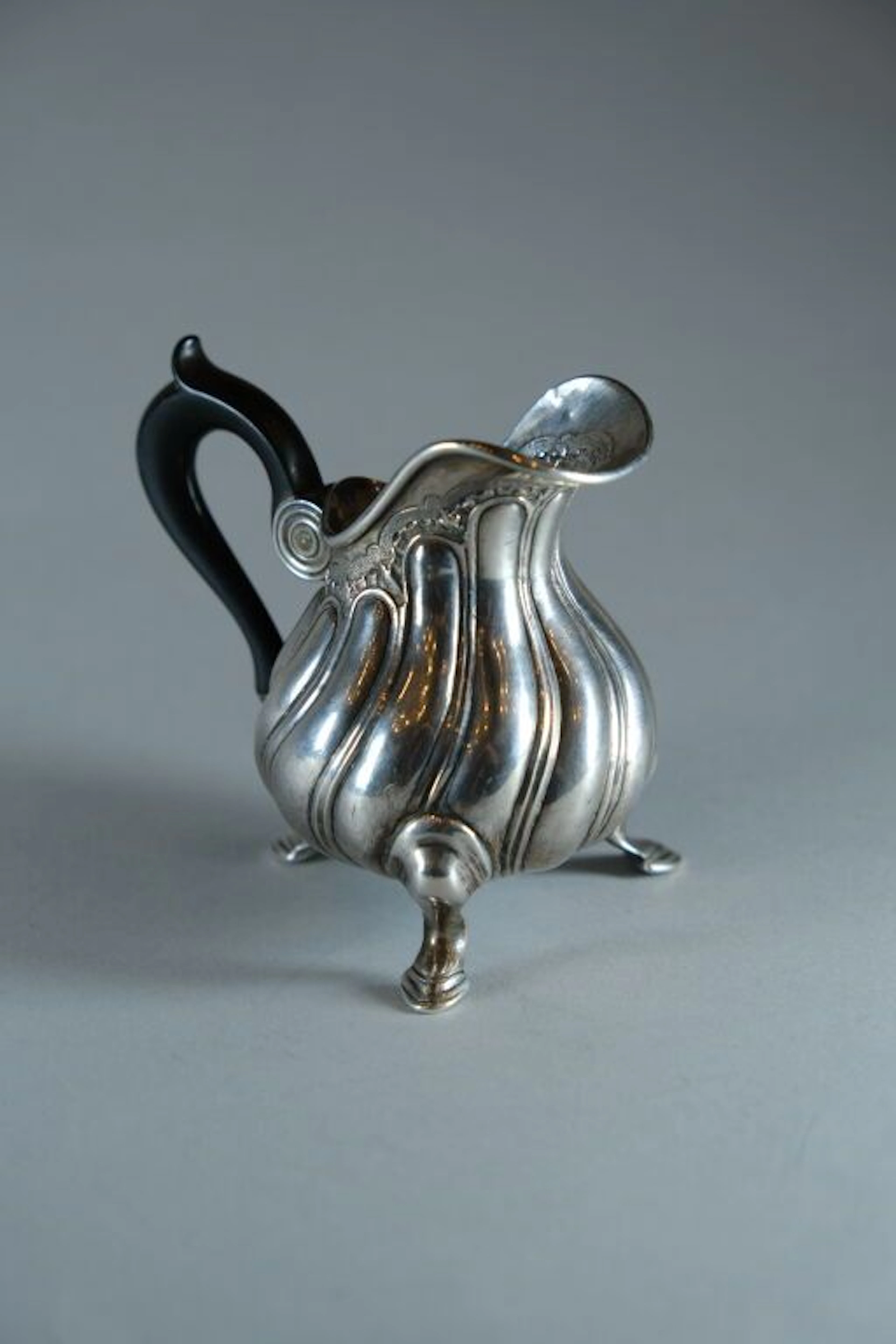 Small three-legged cream pitcher in 958/1000 silver with twisted ribs