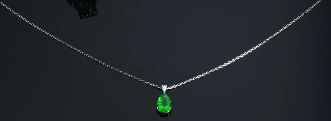 PENDANT in 750‰ white gold set with a pear-shaped emerald weighing