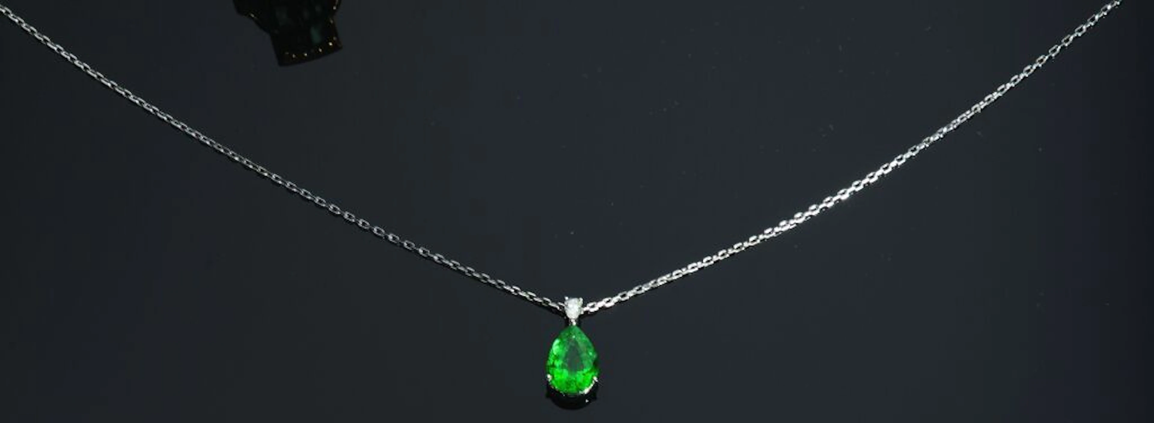 PENDANT in 750‰ white gold set with a pear-shaped emerald weighing