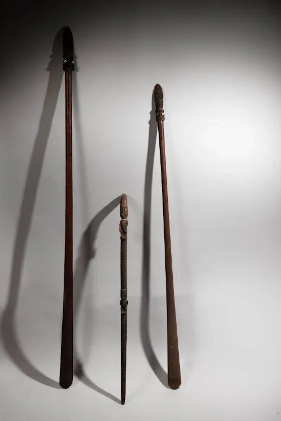 Taiaha weapon adorned at its tip with a double Tiki head sticking