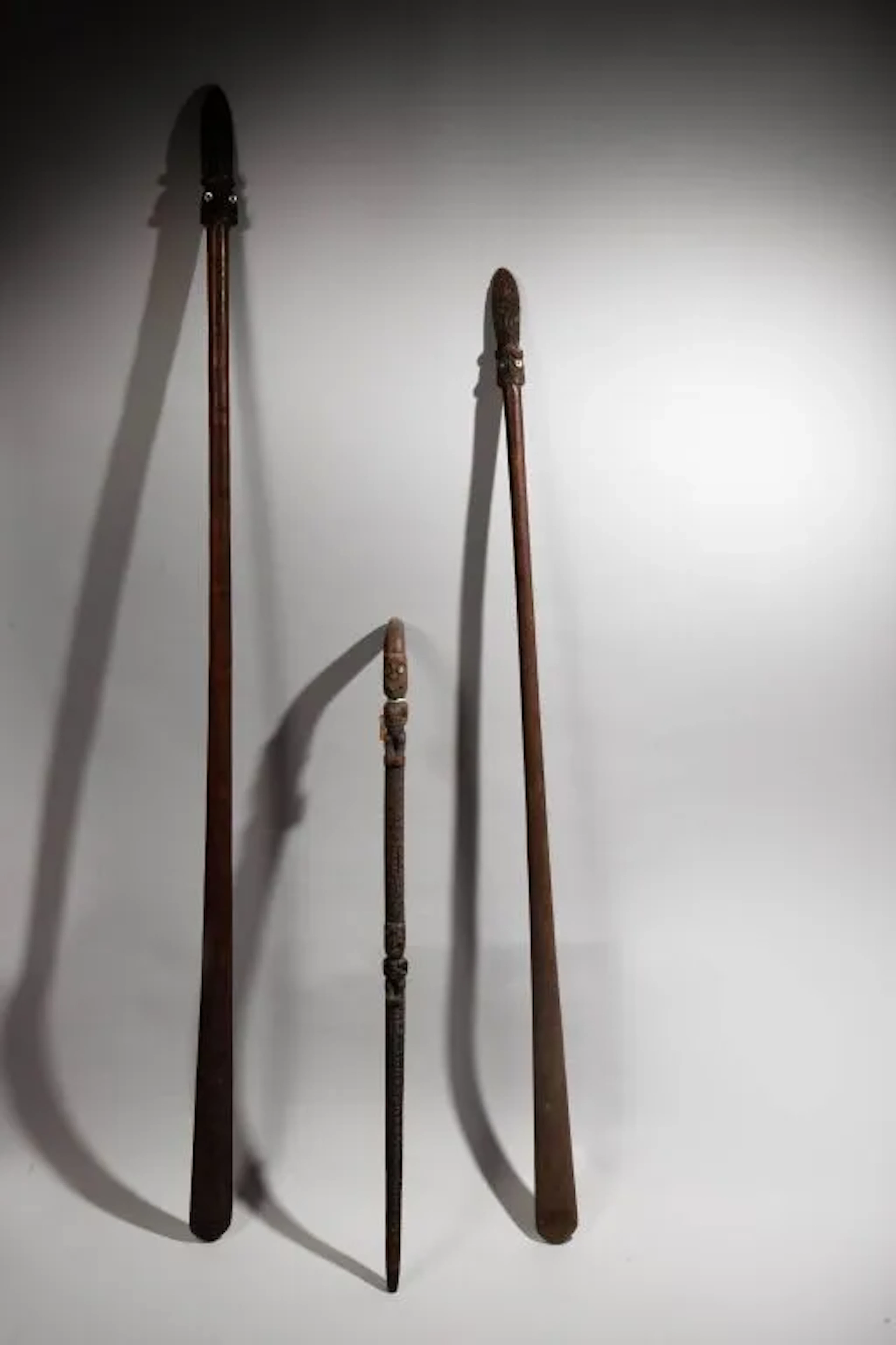 Taiaha weapon adorned at its tip with a double Tiki head sticking