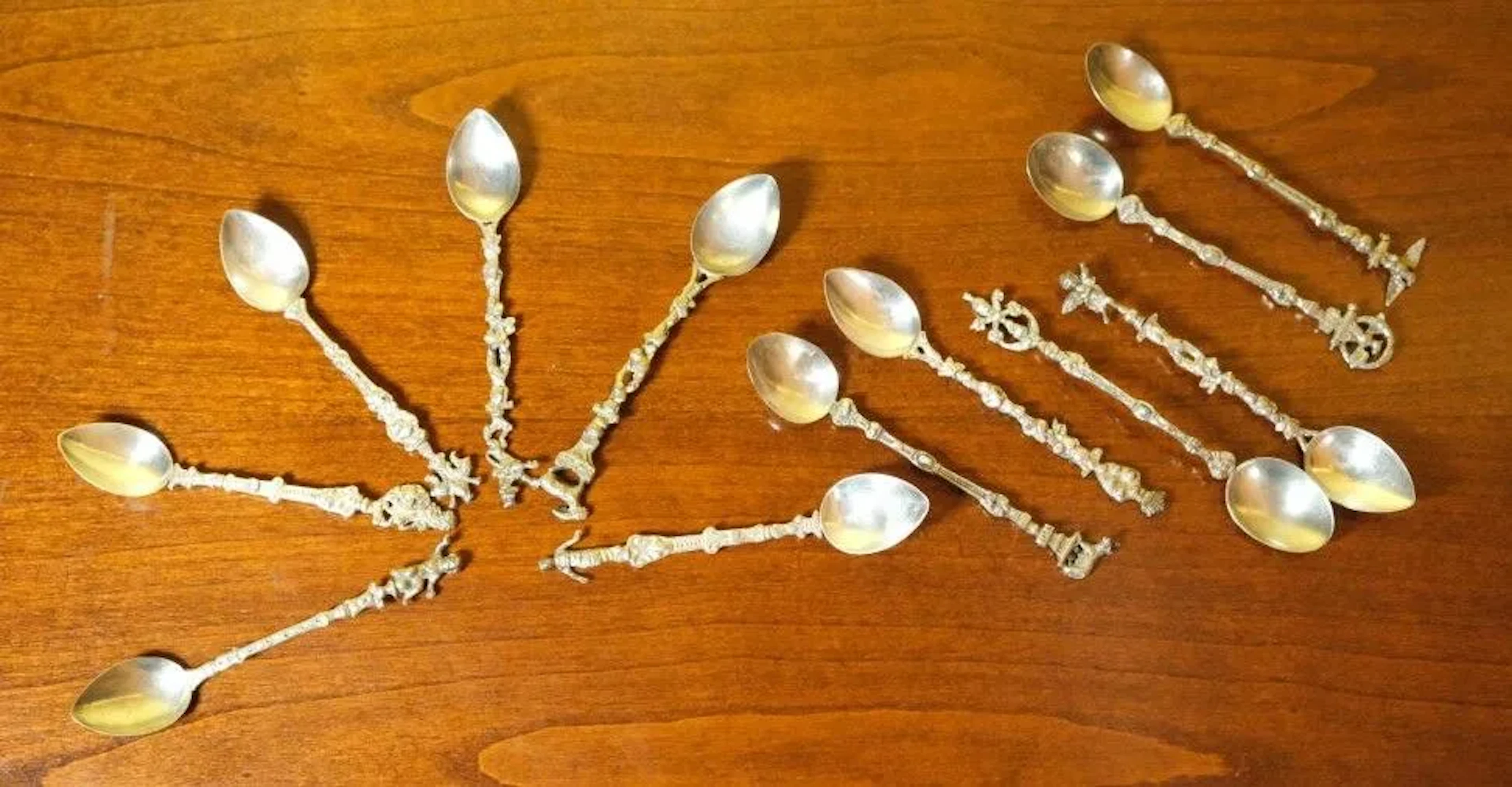 A set of 12 small silver-plated coffee spoons, each featuring a rounded