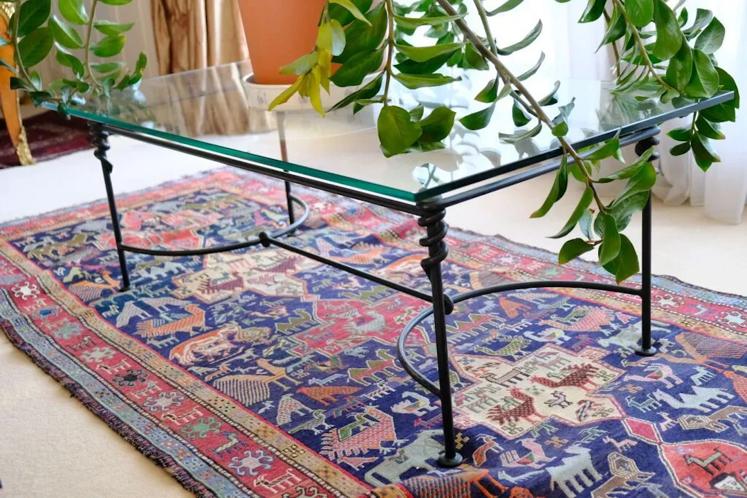 Living room coffee table with a clear glass top resting on a modern