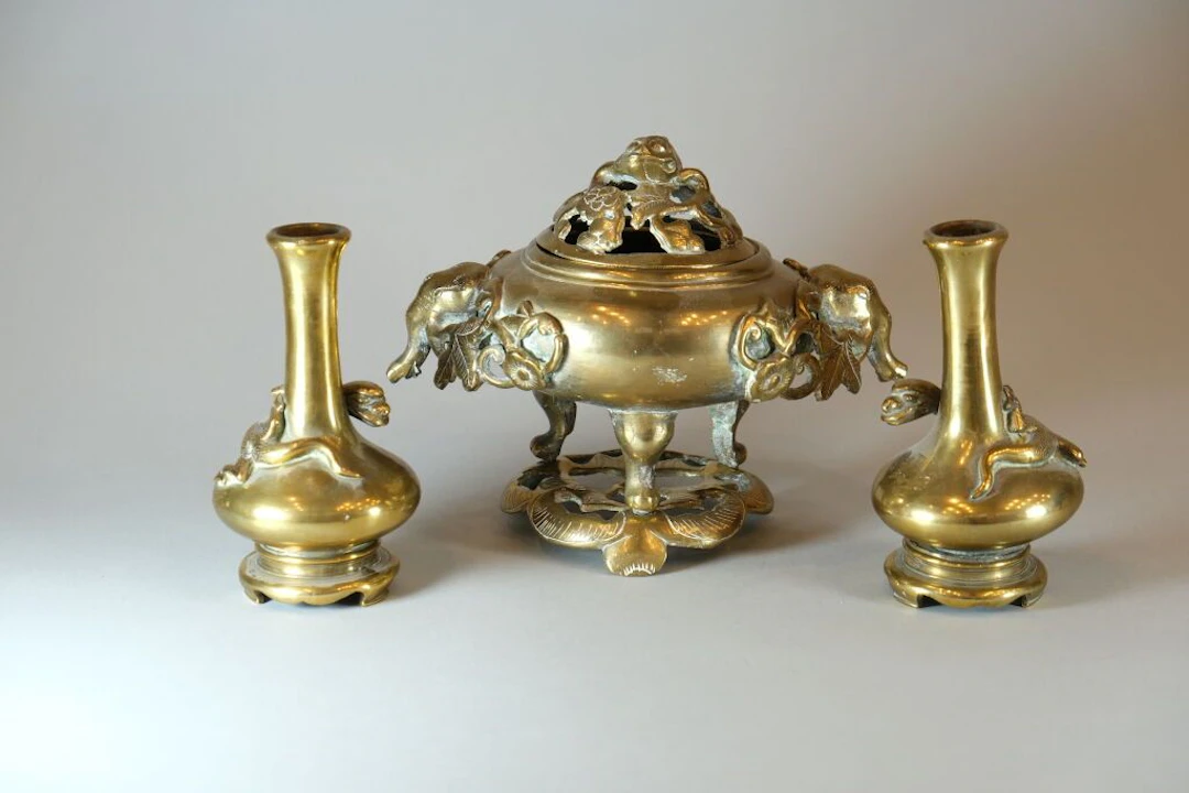 A partially openwork incense burner and two single-flower vases on