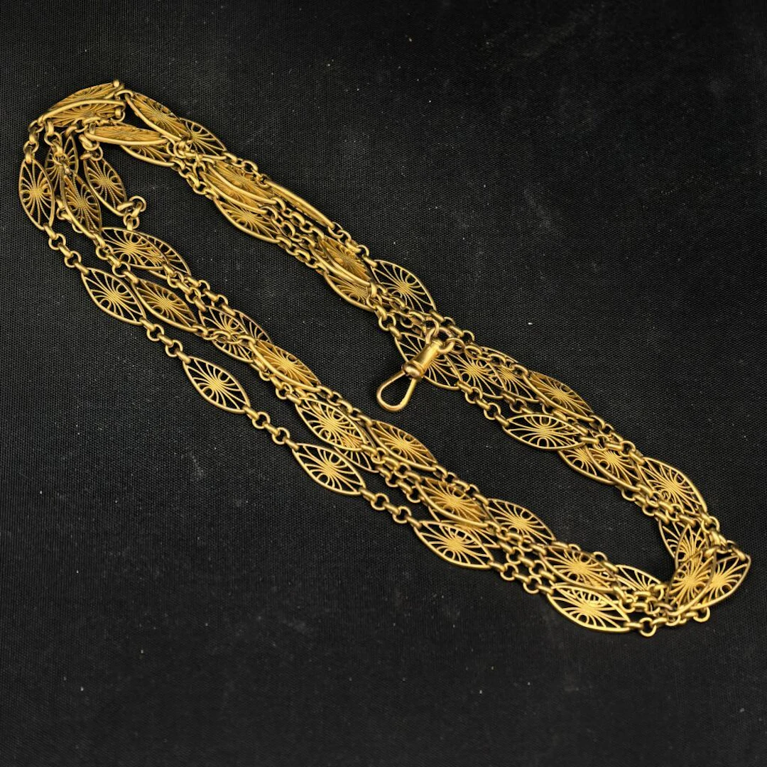 A 750‰ gold chain with filigree motifs, designed as a long necklace.