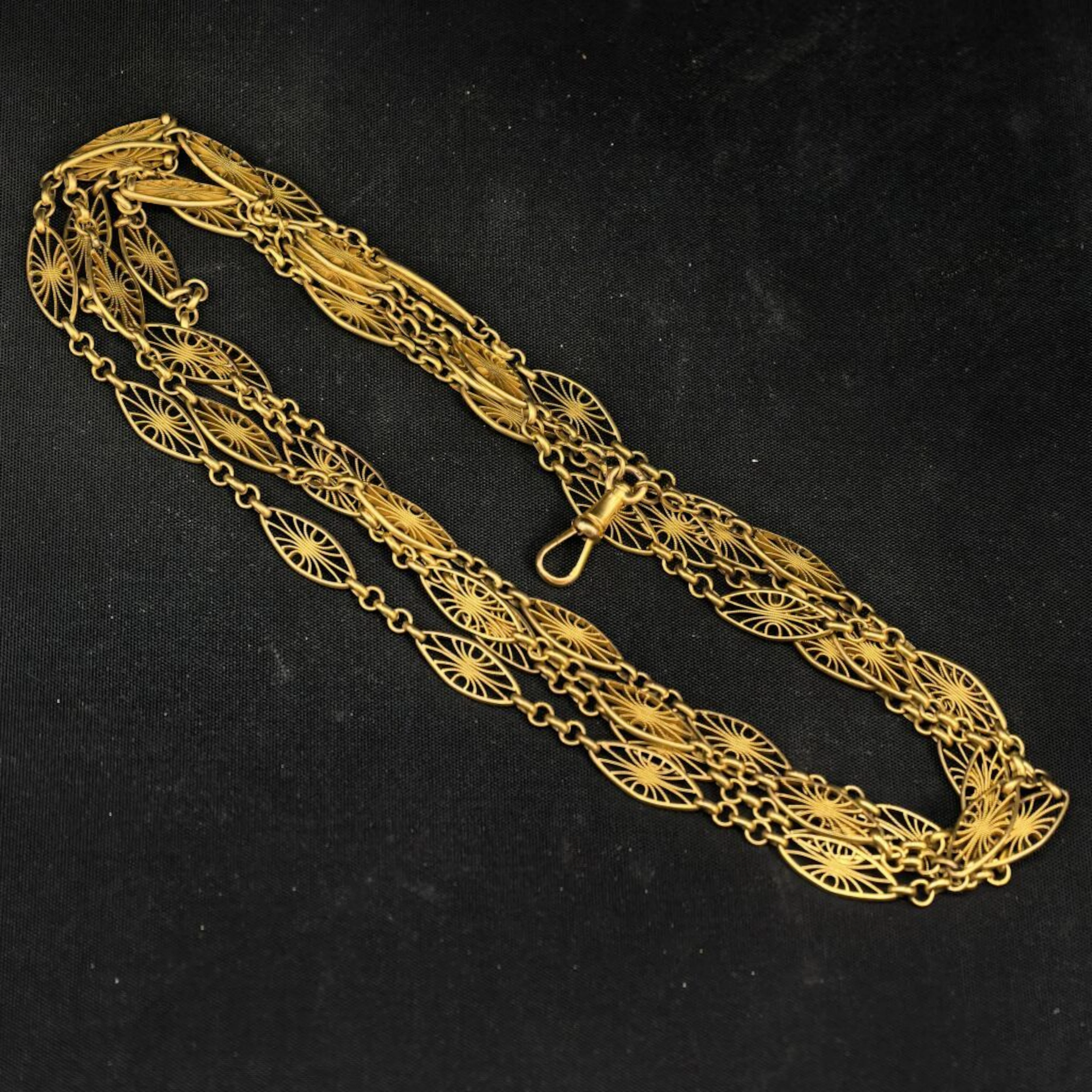 A 750‰ gold chain with filigree motifs, designed as a long necklace.