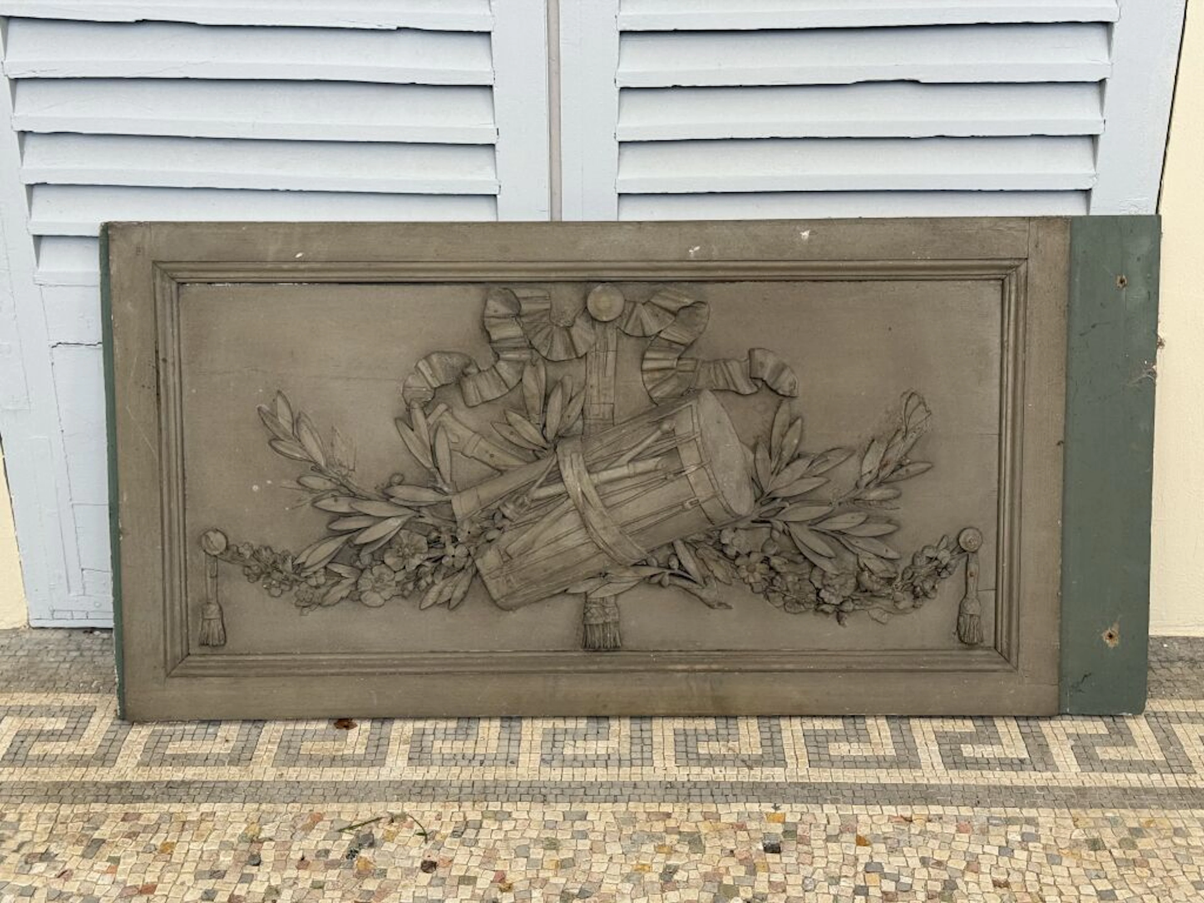 Wood panel with a gray-stained finish, carved with an allegory of