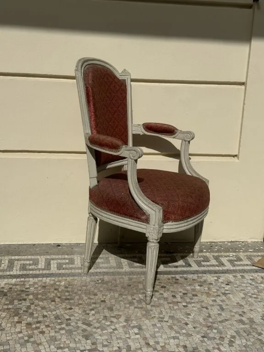 Molded wooden armchair with a cream-colored finish. Tapered legs with