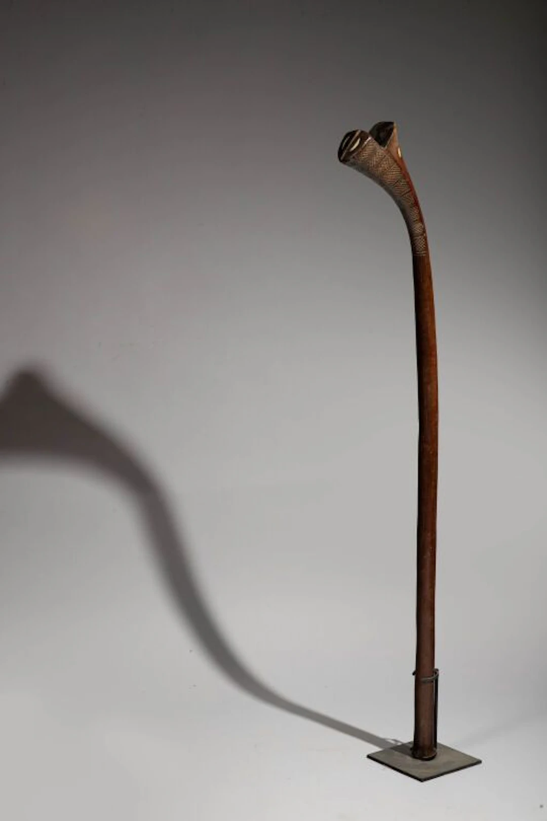 A club shaped like a rifle butt, inlaid with half-moon-shaped mother-of-pearl