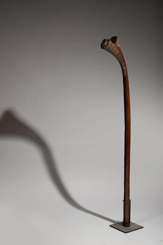 A club shaped like a rifle butt, inlaid with half-moon-shaped mother-of-pearl
