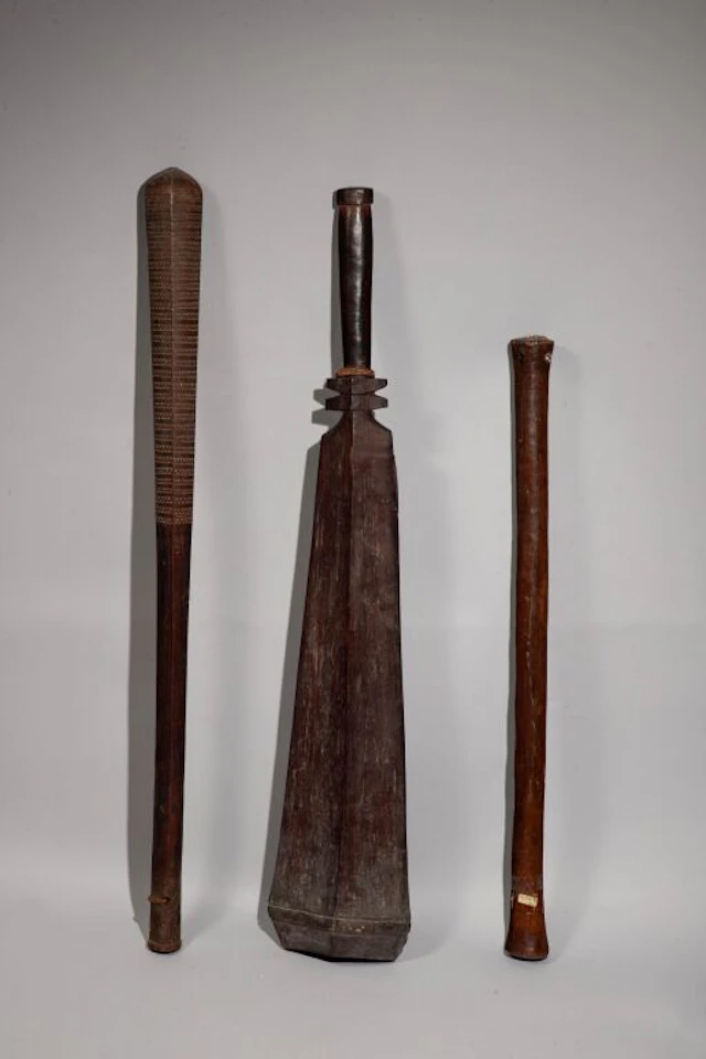 A circular club decorated with incisions on both ends and inlaid with