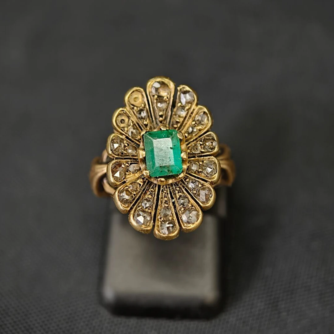 A 750‰ yellow gold ring featuring a floral motif centered with an