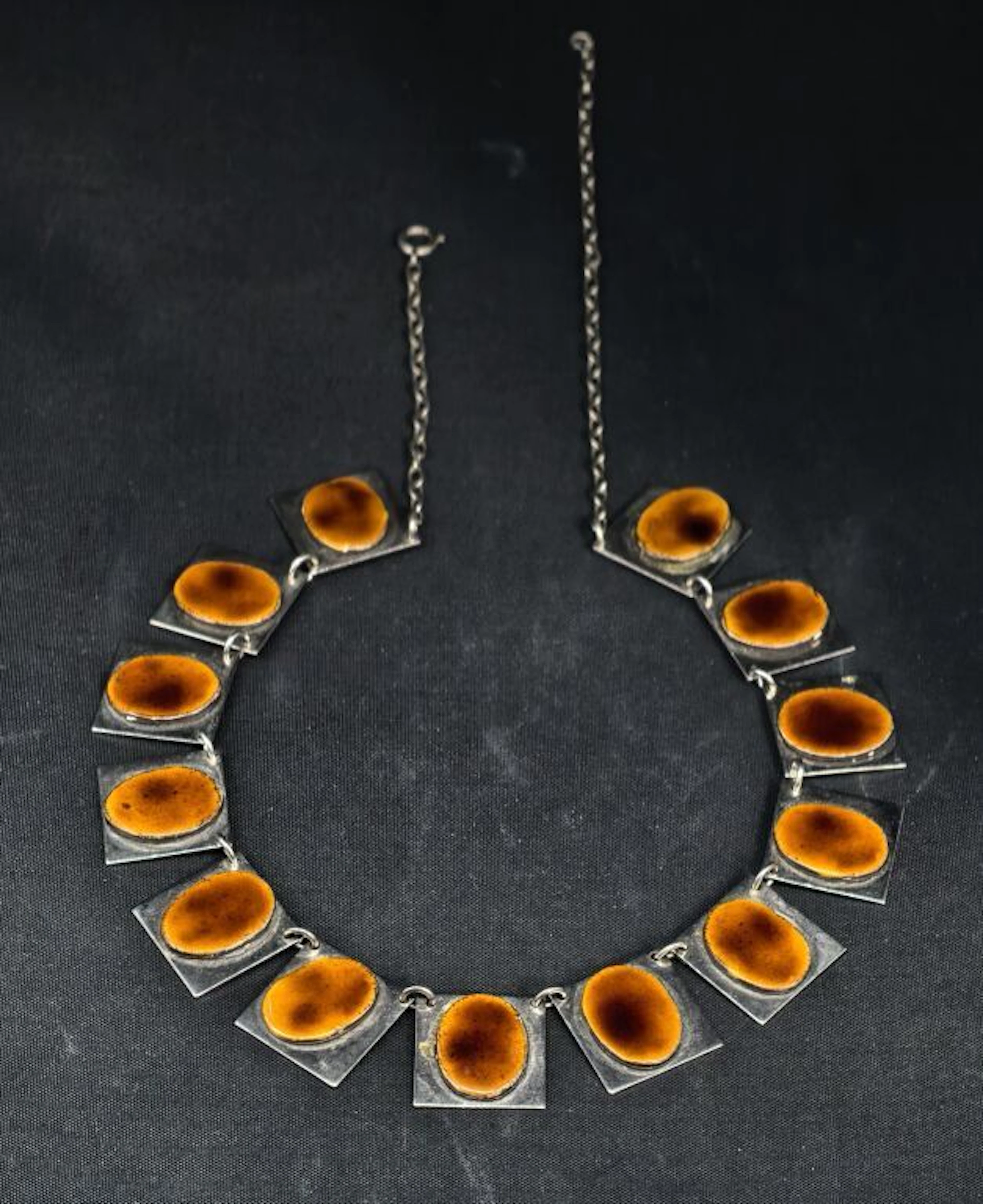 A flat, link-style necklace consisting of a series of square plates