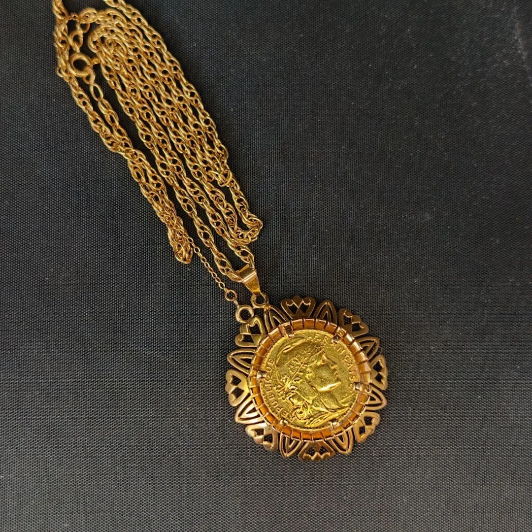 A 750‰ yellow gold chain with double forçat links, holding a 20 F