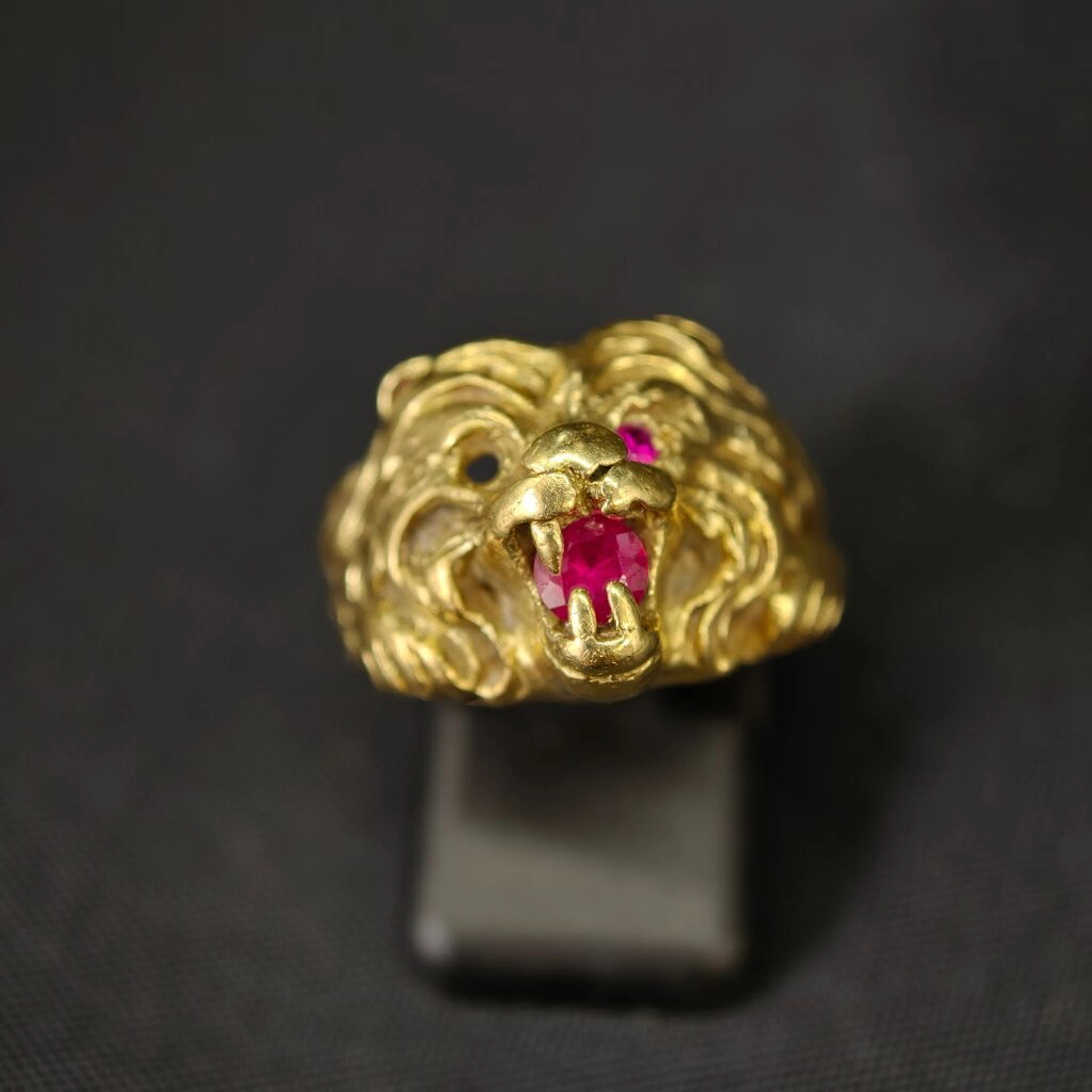 A 750‰ yellow gold ring featuring a lion's head holding an imitation