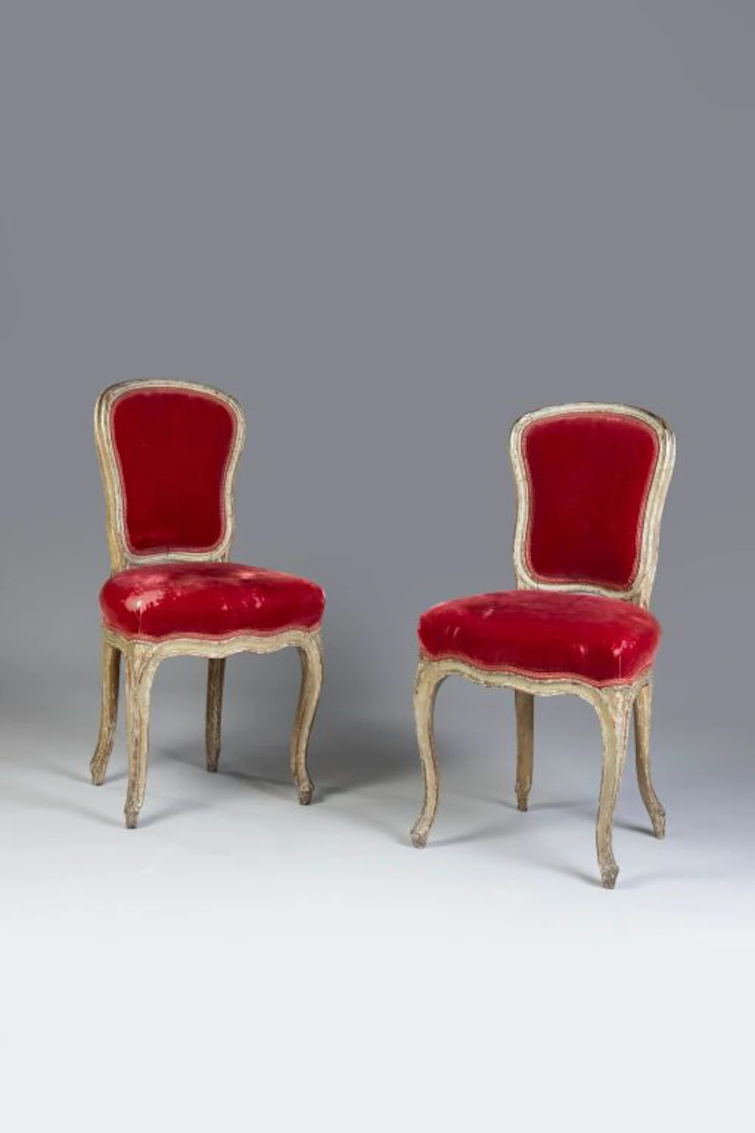 A set of two cabriolet-style chairs with violin-backrests, featuring