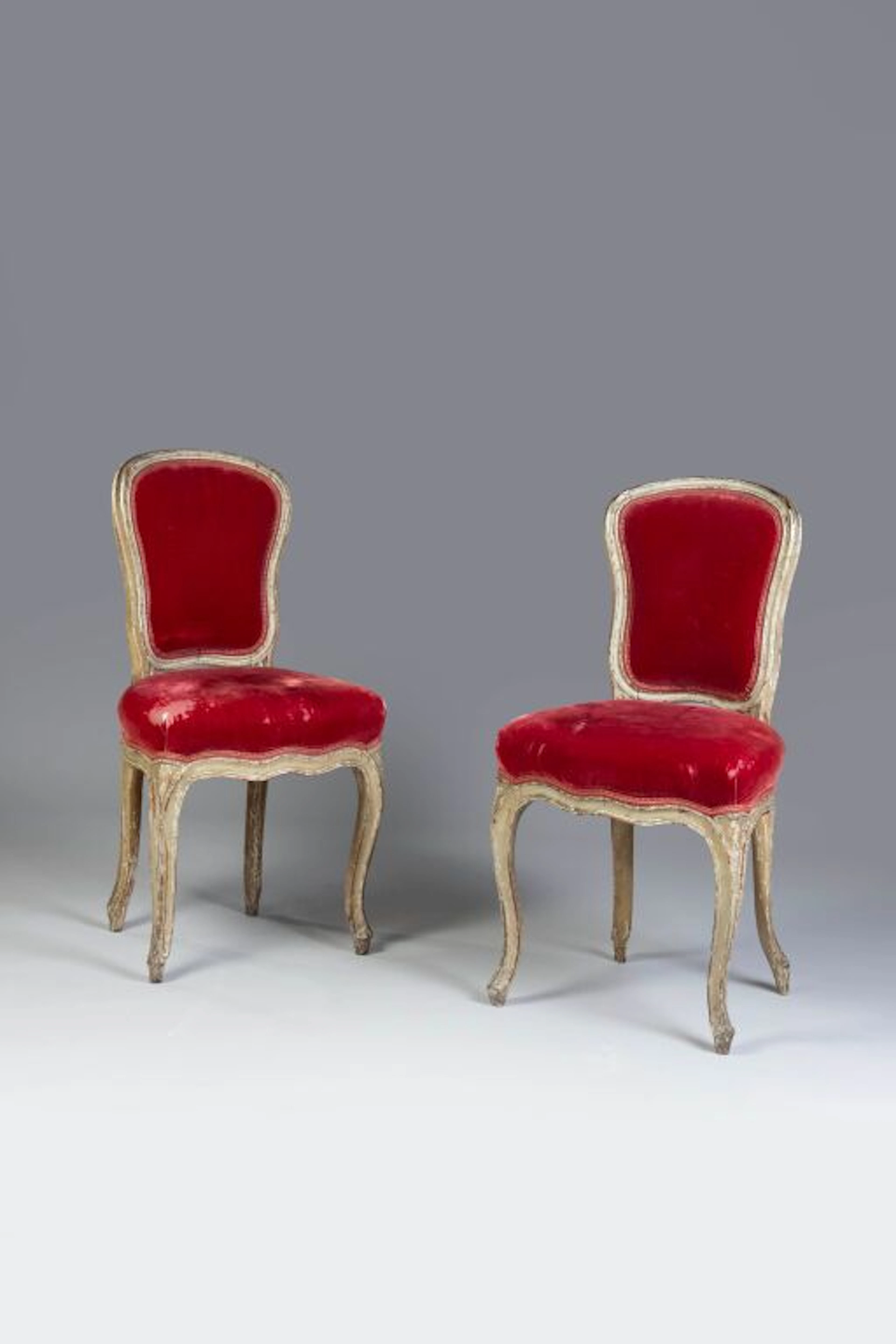 A set of two cabriolet-style chairs with violin-backrests, featuring
