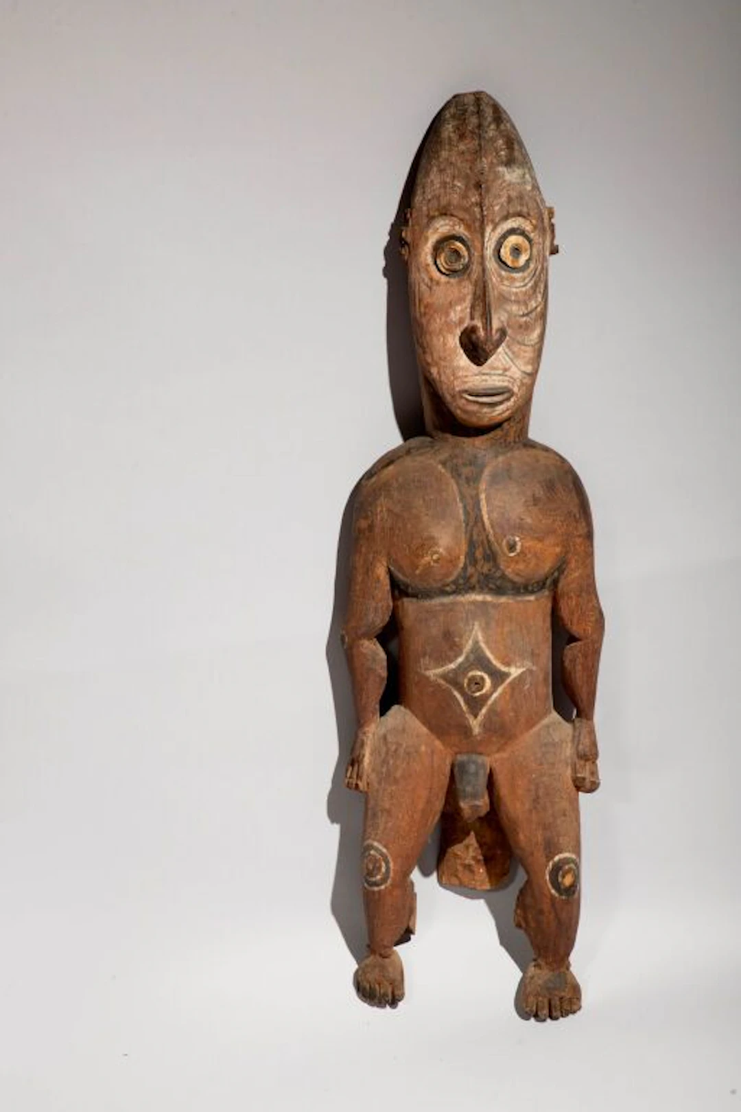 Male figure with circular seashells inlaid in the eyes (back of an