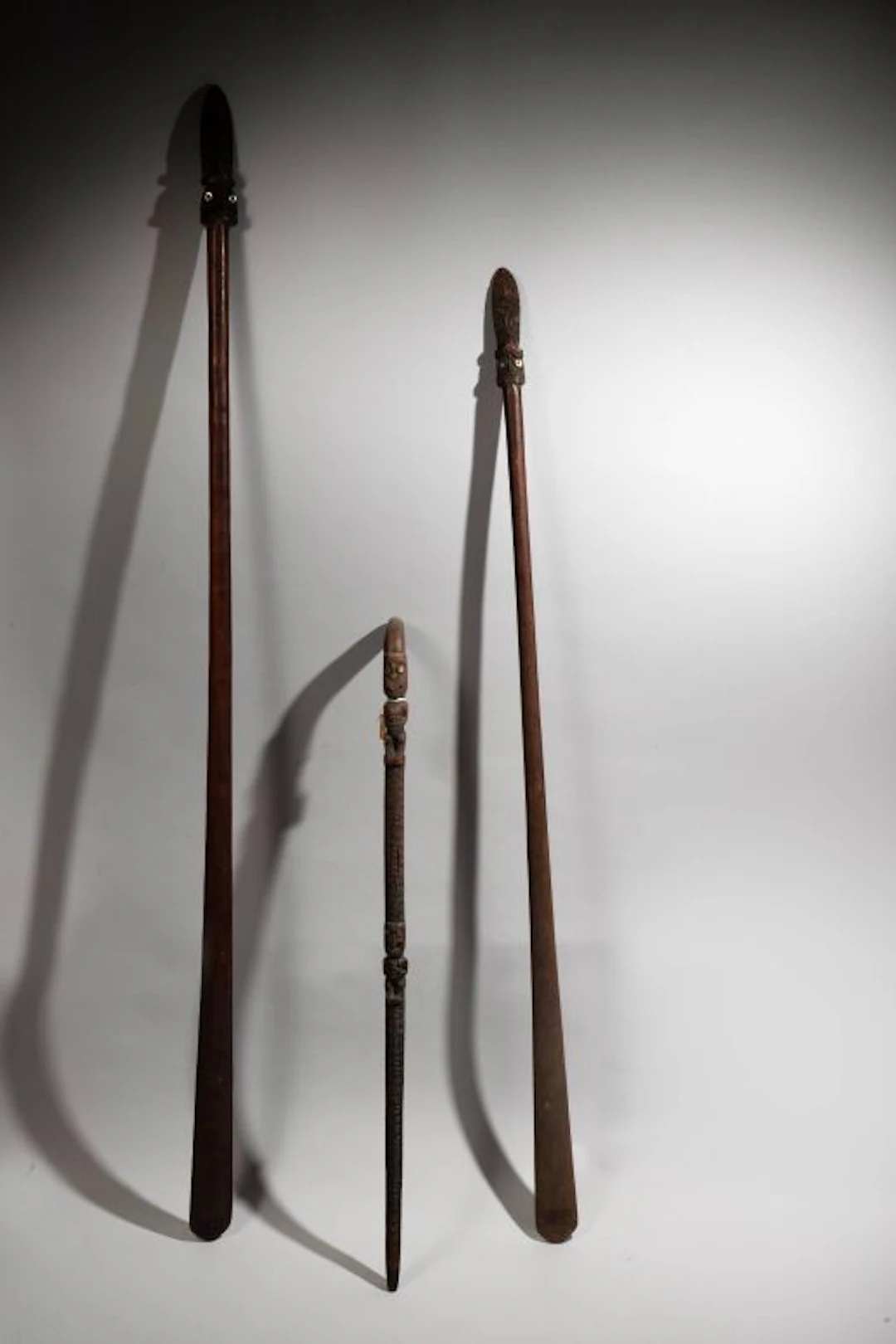 Taiaha weapon with a tip carved with two tikis whose eyes are inlaid