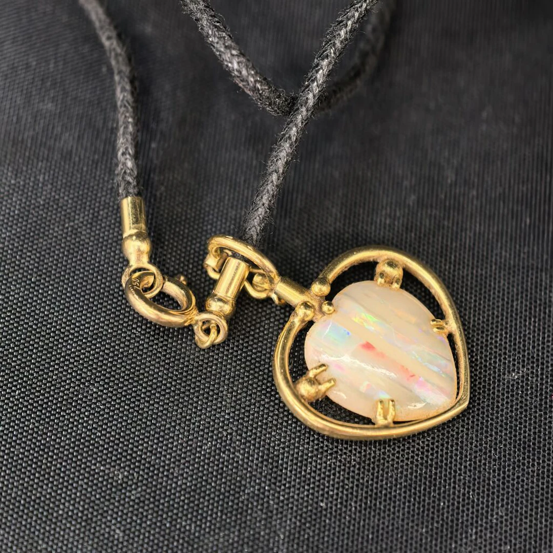 A 750‰ yellow gold pendant featuring a removable heart-shaped charm
