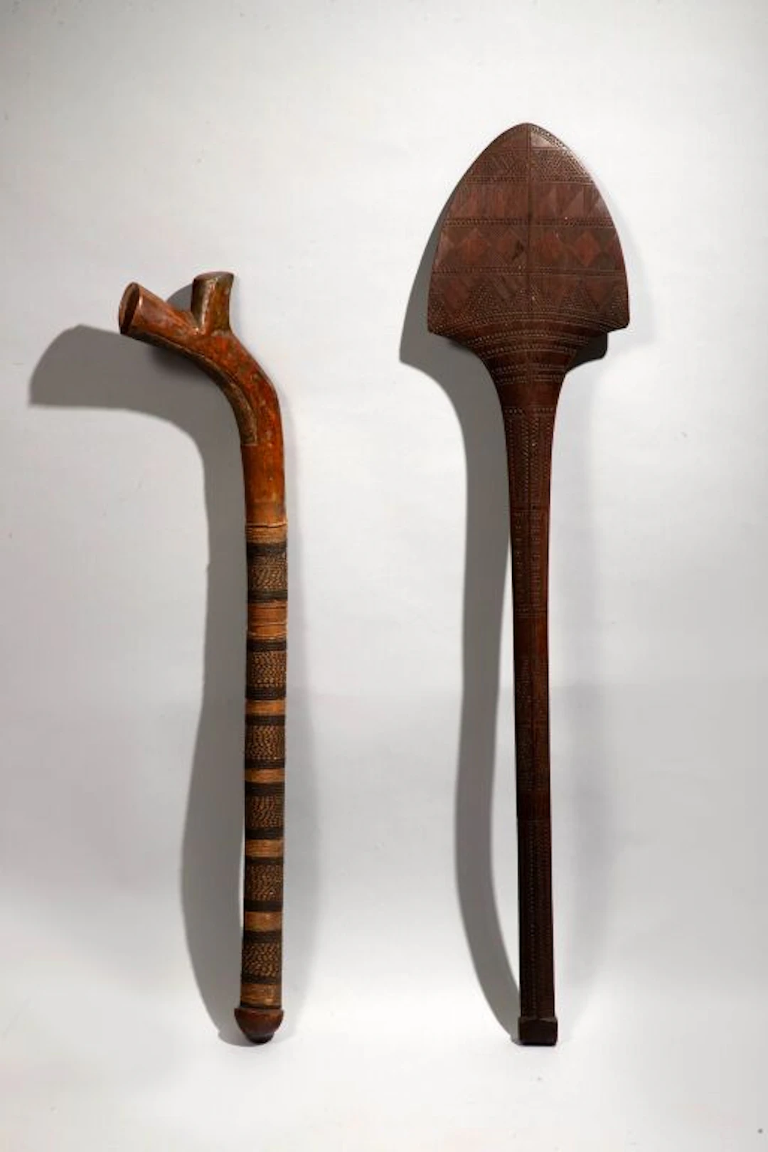Fan-shaped club with a quadrangular pommel covered in geometric patterns.