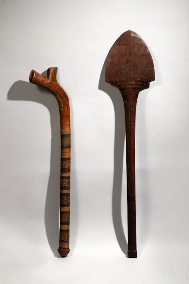 Fan-shaped club with a quadrangular pommel covered in geometric patterns.