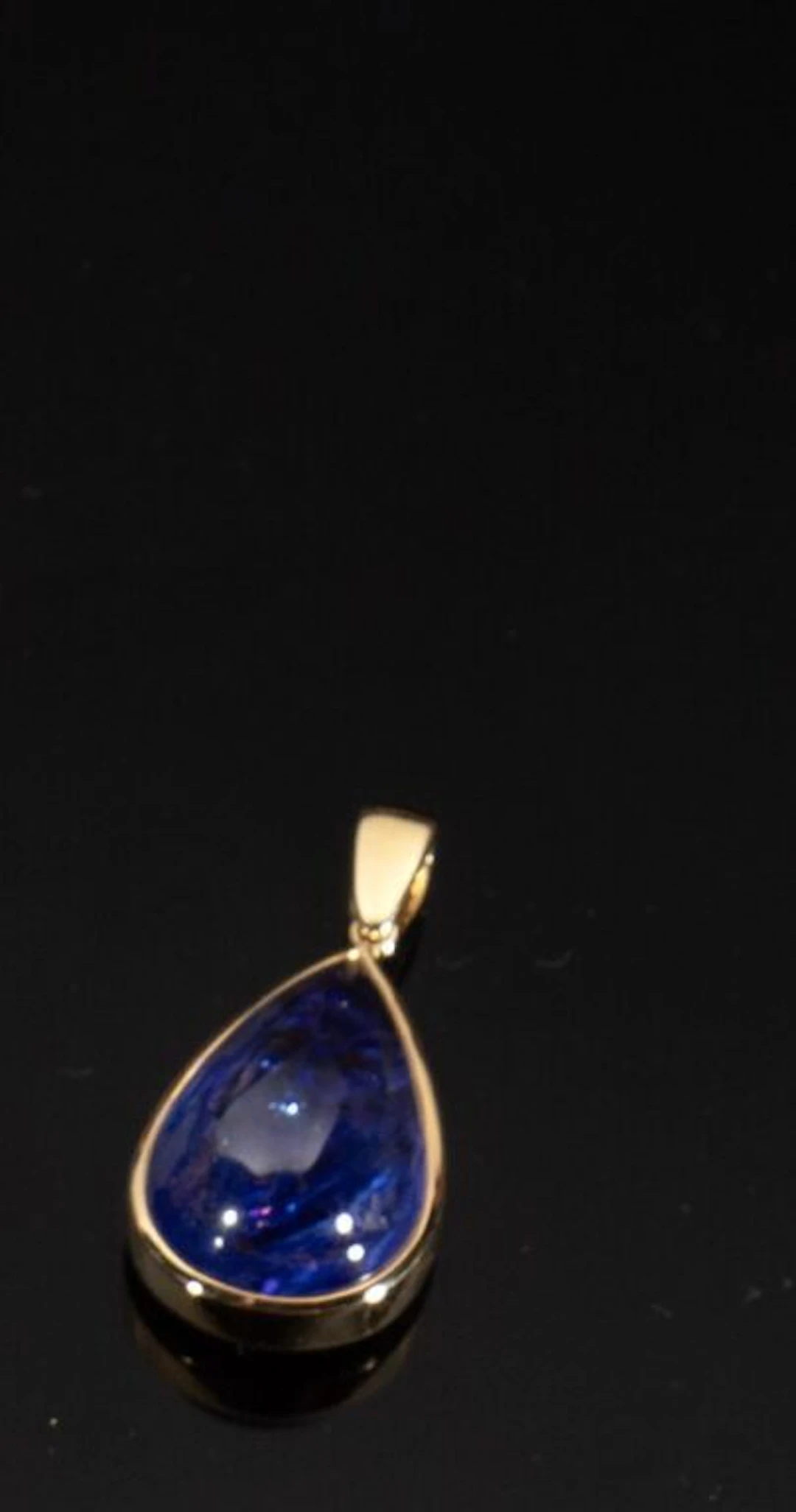 750‰ yellow gold pendant set with a pear-shaped cabochon-cut tanzanite.