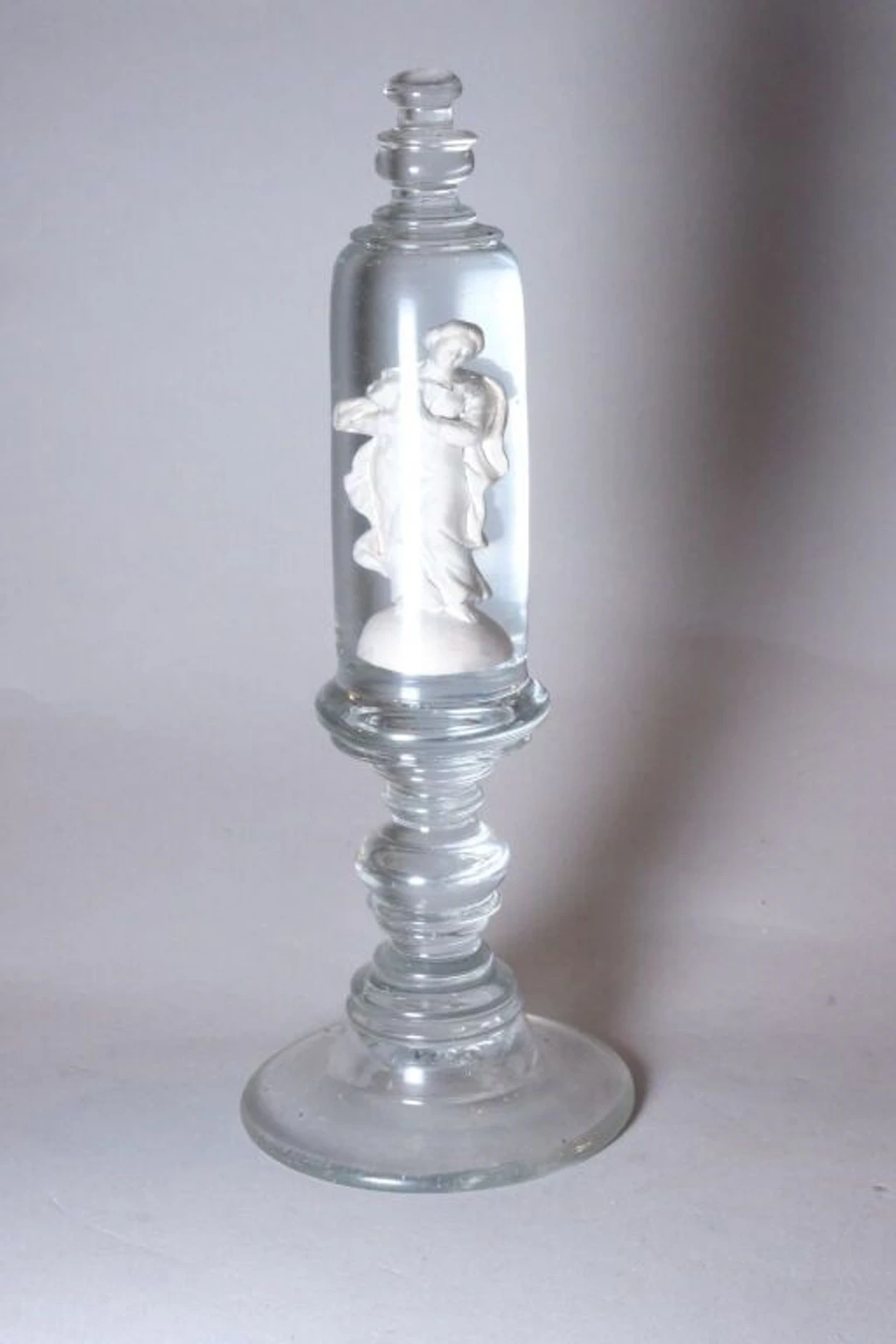 Virgin Mary in a cylindrical, molded pressed-glass structure with