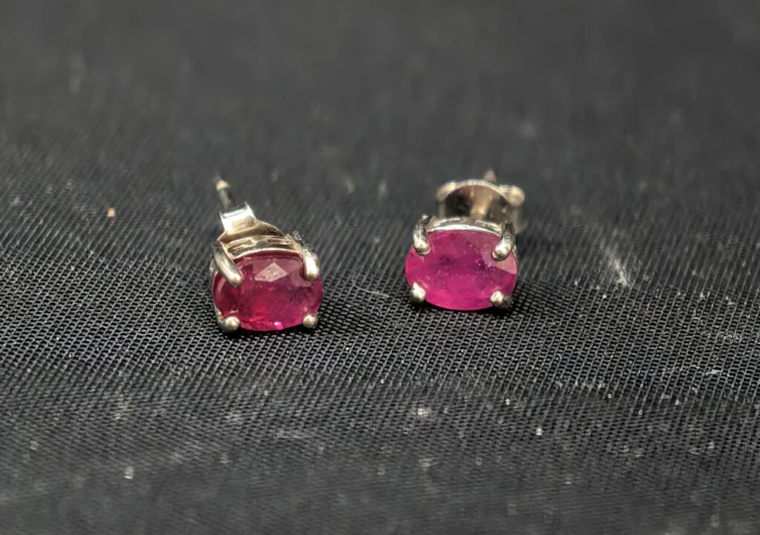 A pair of 925‰ silver stud earrings set with small oval-shaped treated