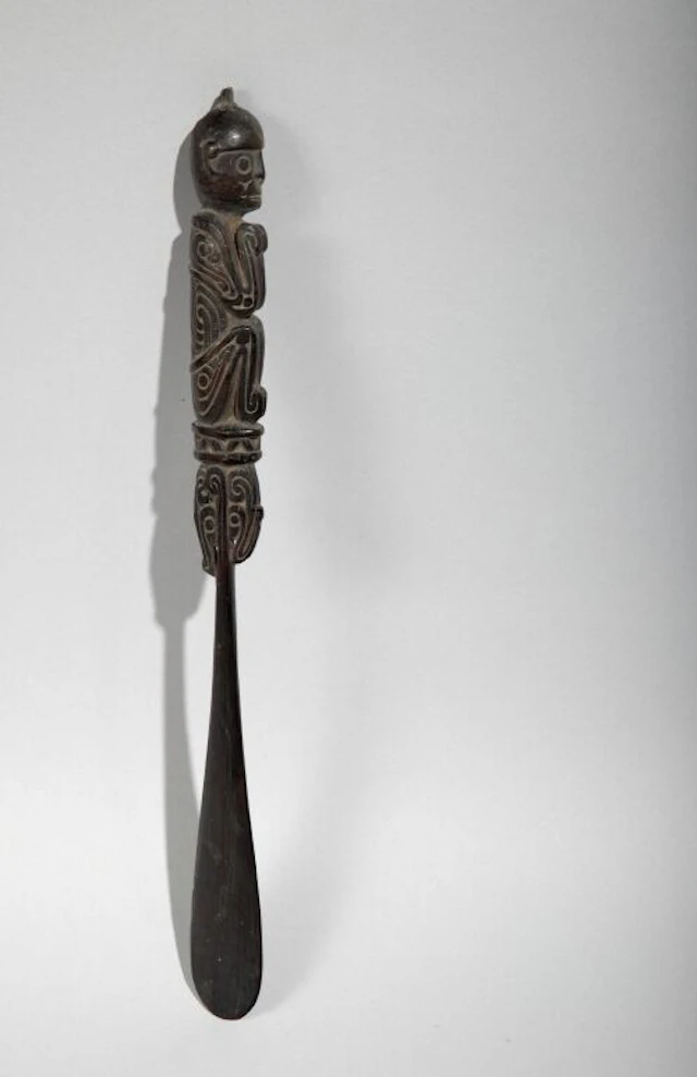 Lime spatula carved with a seated figure. Black hardwood. Trobriand