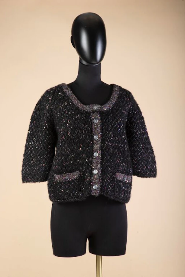 CHANEL - Cruise Collection. Collarless jacket in black wool knit with