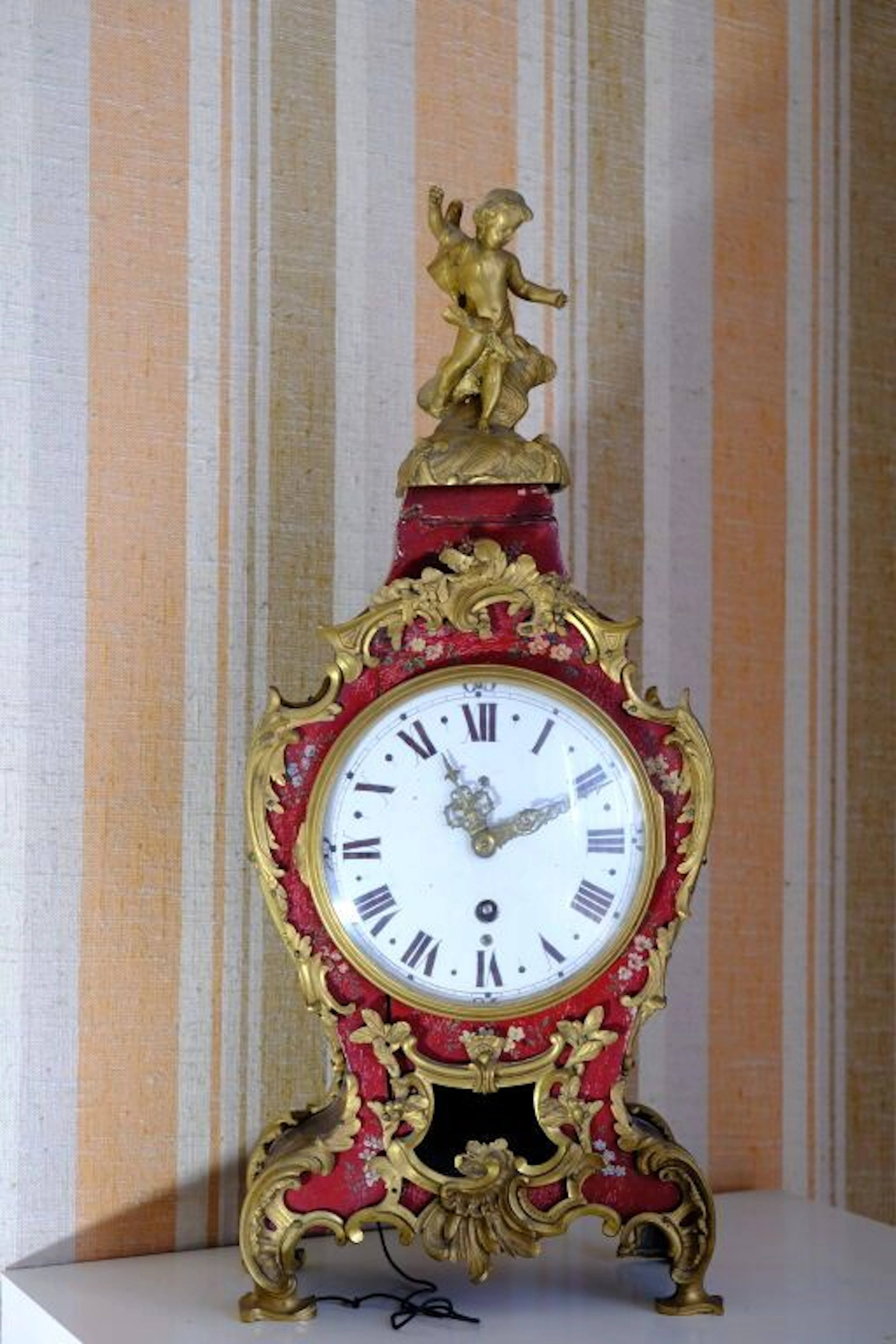 Small red-lacquered wooden table clock with painted floral decoration;